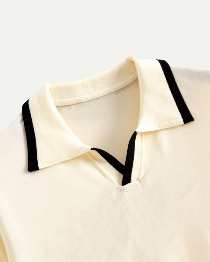 Close-up of beige knit polo collar with V opening and contrast trim stitching