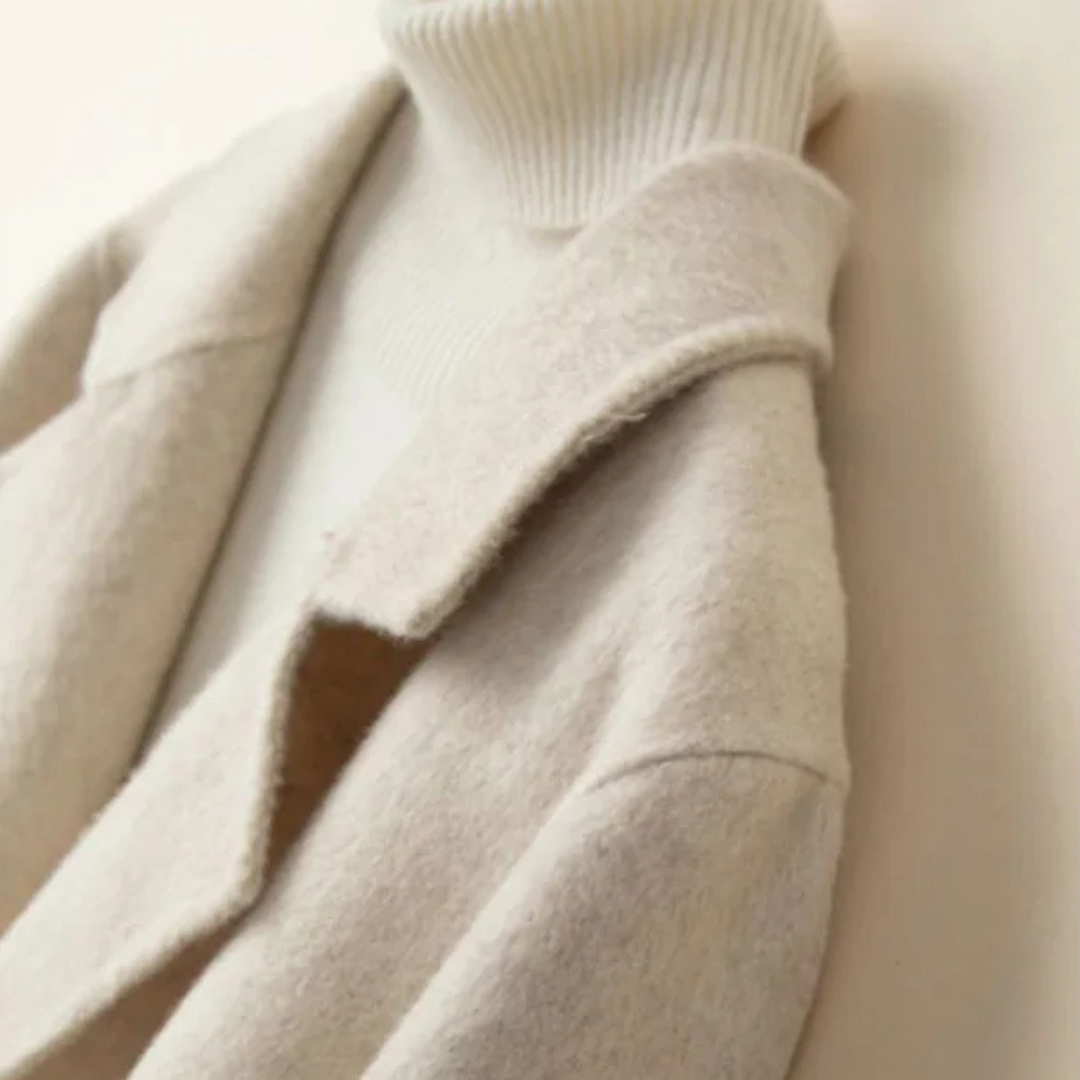 Close-up of the cream ladies overcoat layered over a knit — Aveloire