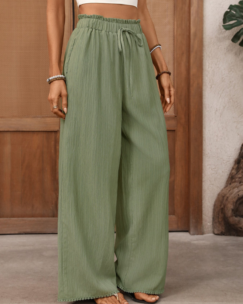 model wearing green wide leg trousers high waisted drawstring waist front view