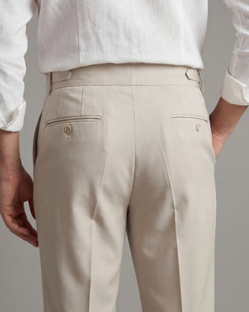 Back view male model wearing beige tailored dress trousers rear pocket detail