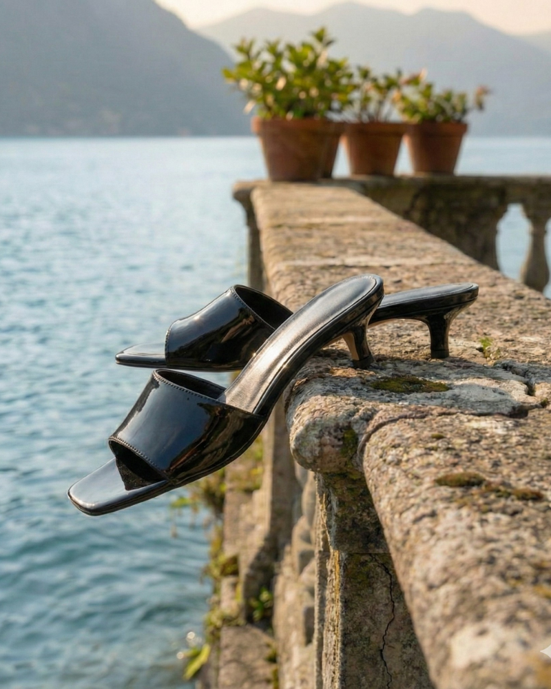 Women’s black slip-on kitten heel sandals styled on terrace setting