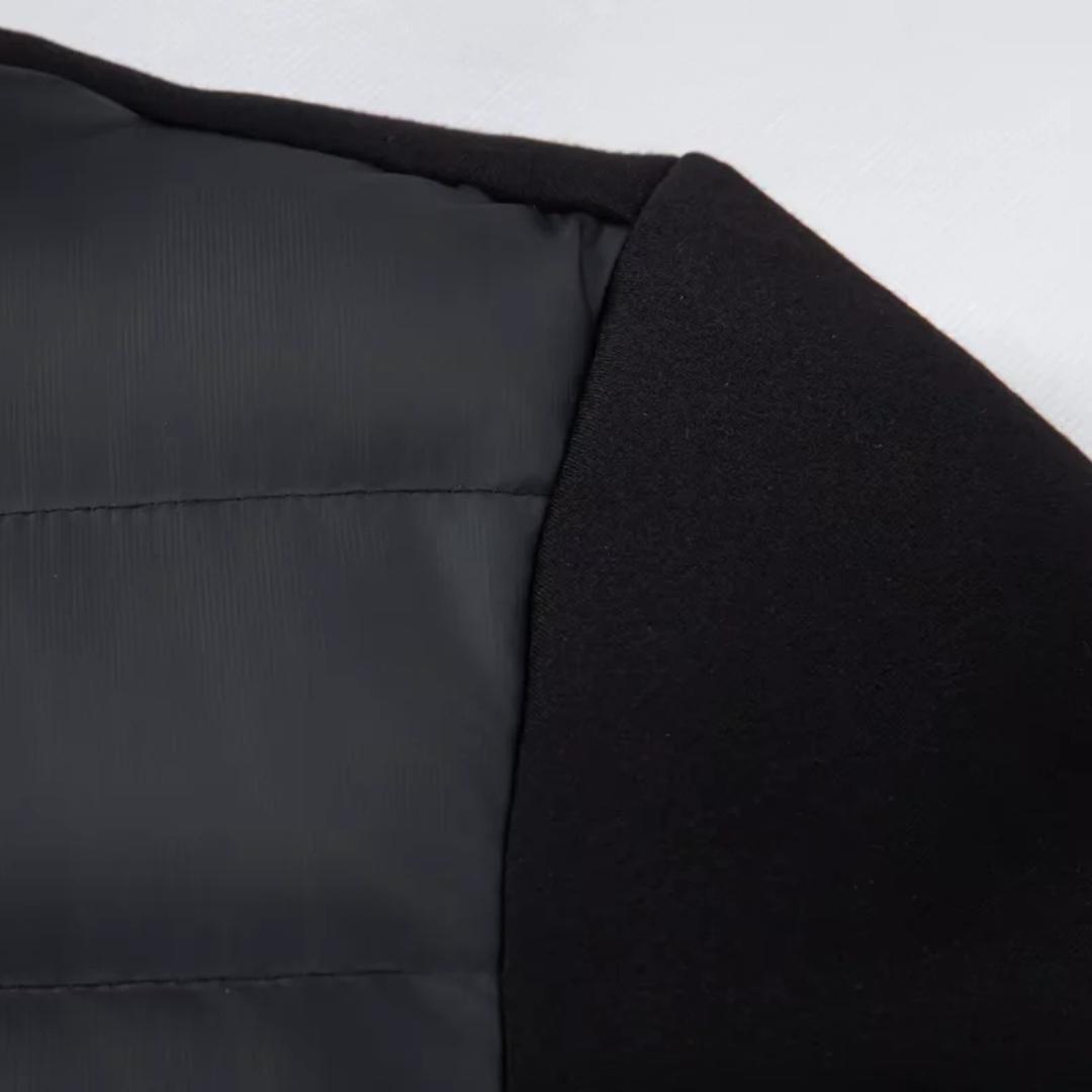 Close-up of the knit sleeve panel meeting the quilted body of the down puffer jacket — Aveloire