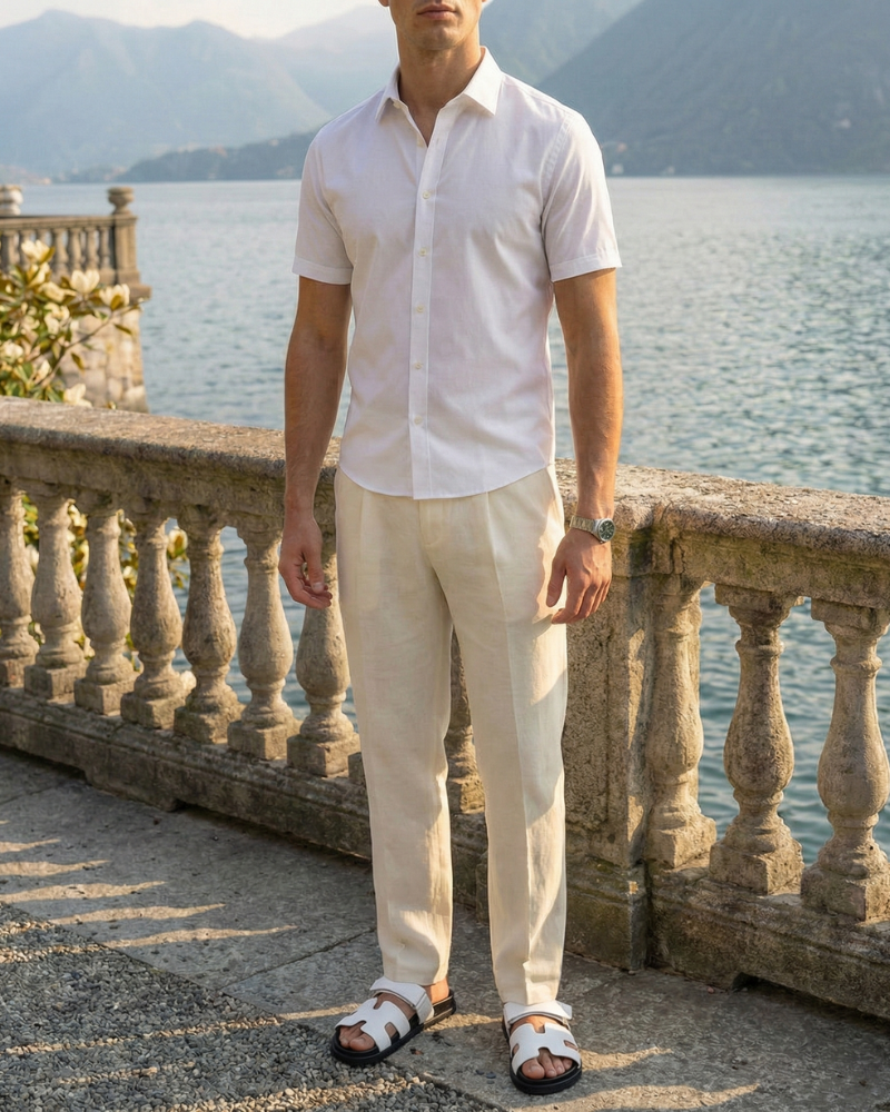 Men’s white short sleeve slim fit button-up shirt styled with light trousers