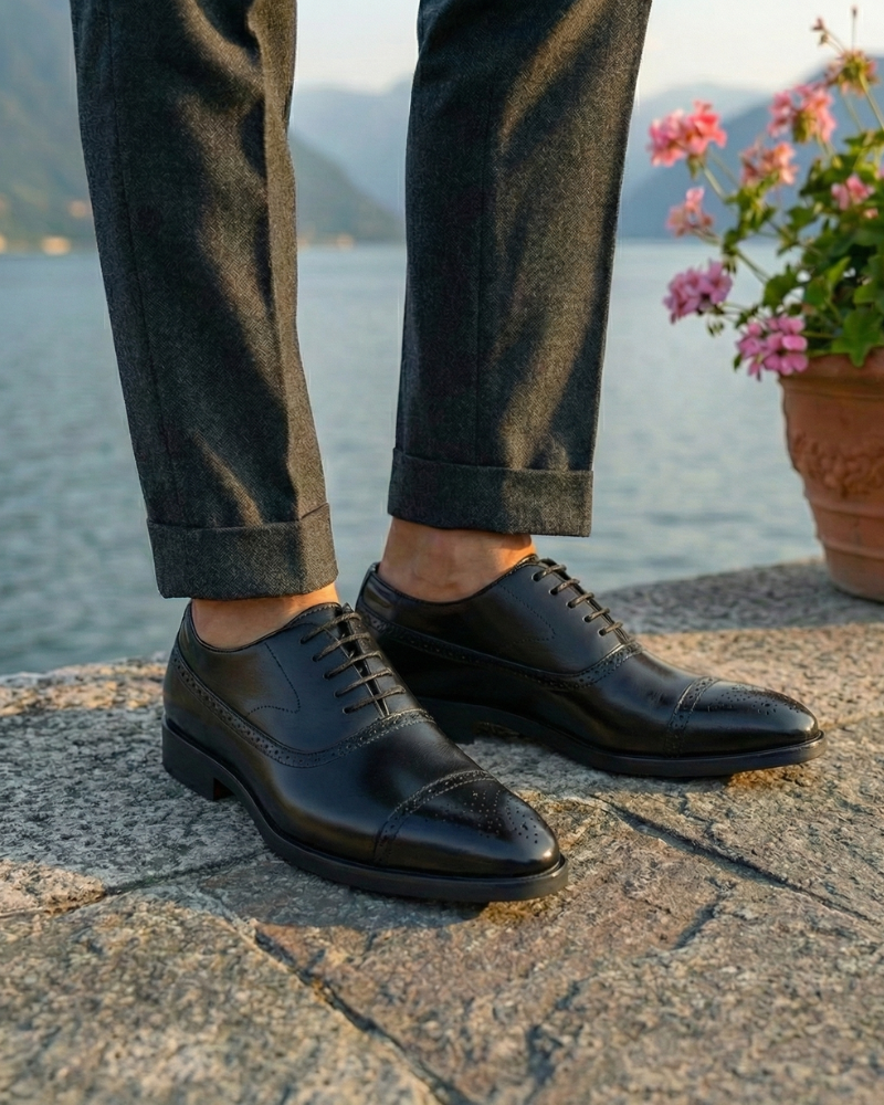 Men’s black leather lace-up dress shoes styled with tailored trousers