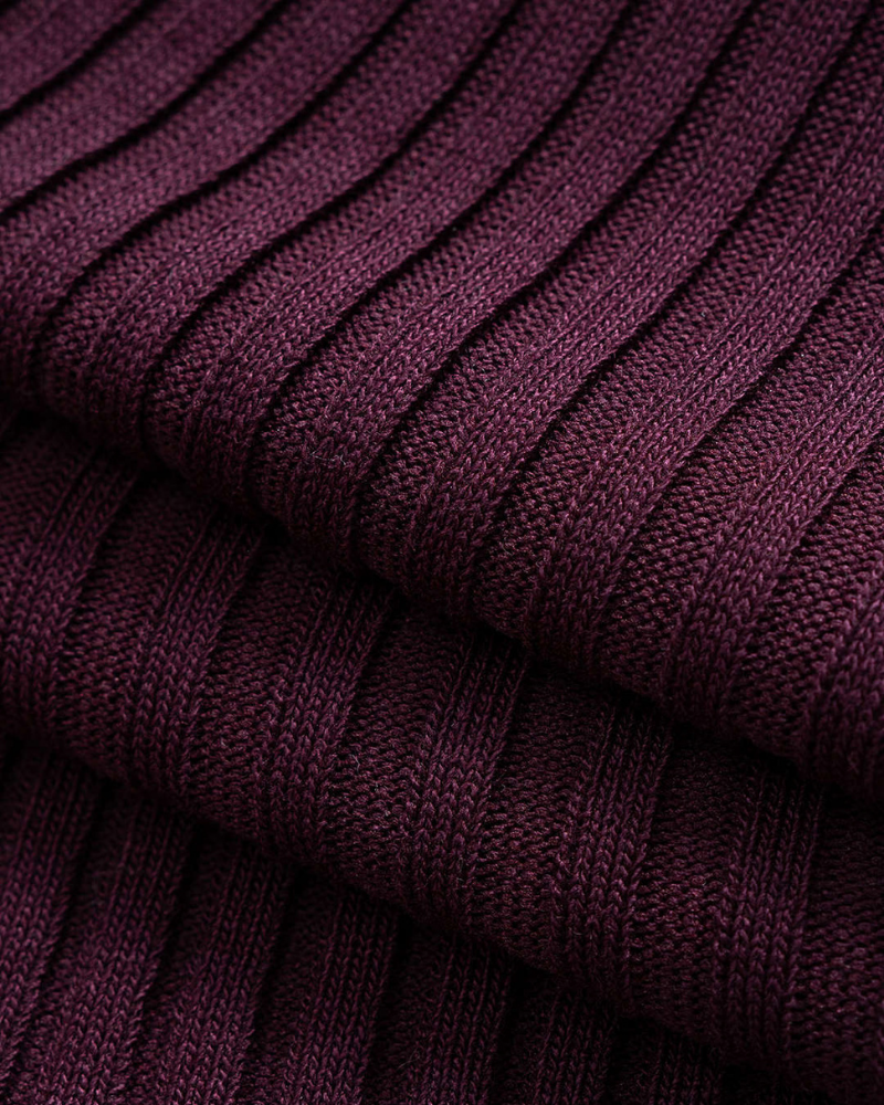 Close-up of burgundy ribbed fabric texture on fitted polo midi dress