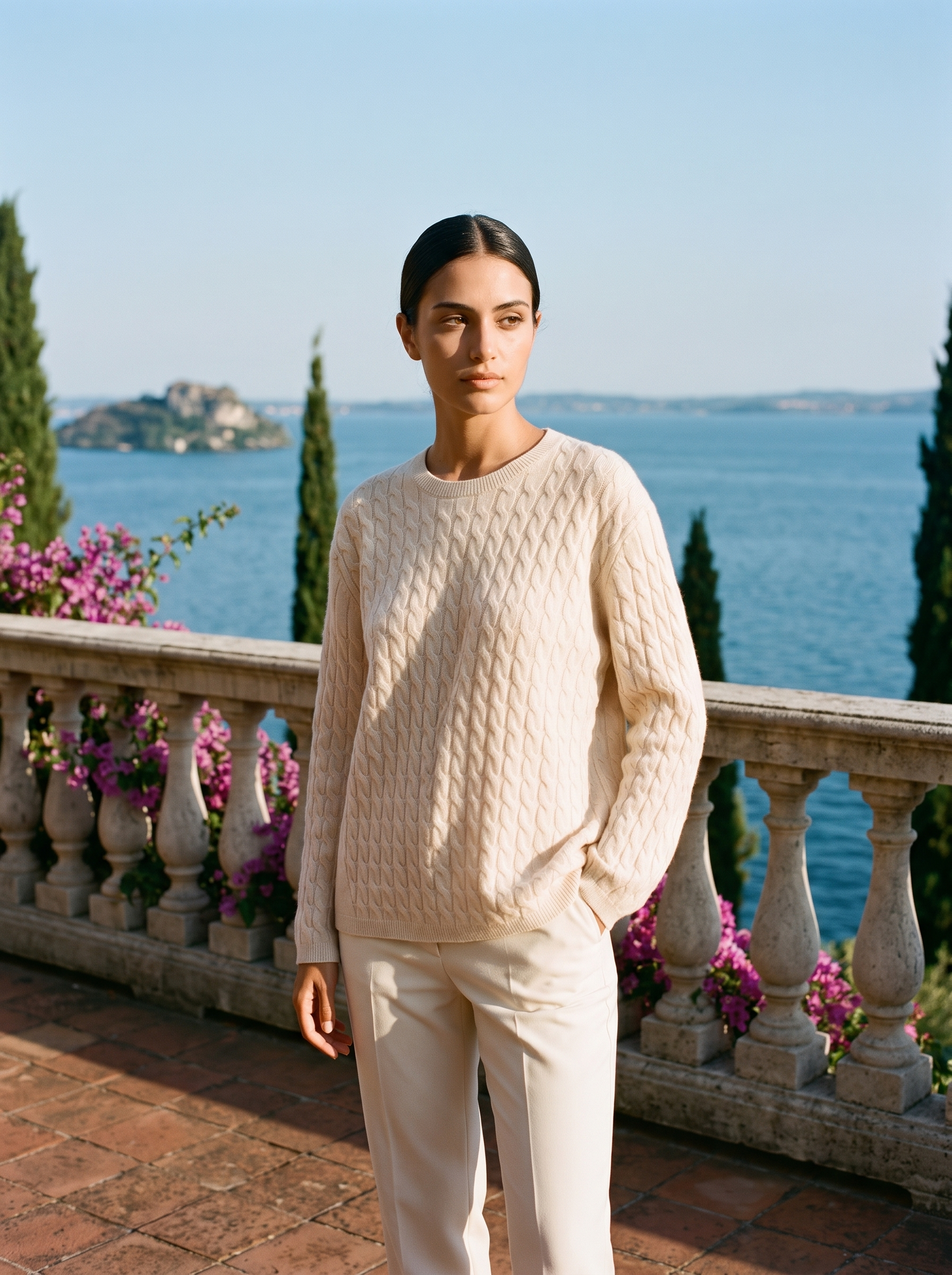Woman in a cream cable-knit jumper, full-length front view on a Lake Como terrace — Aveloire