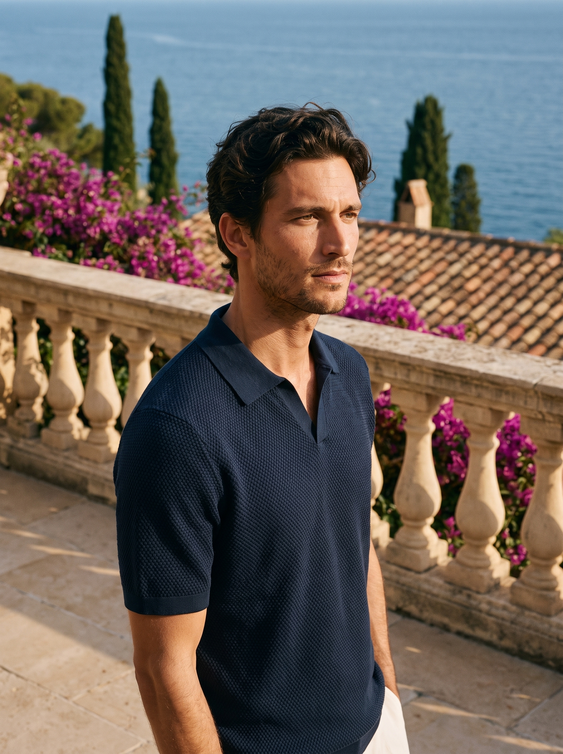 Man wearing a dark navy textured knit polo on a balcony overlooking Lake Como, old money style — Aveloire