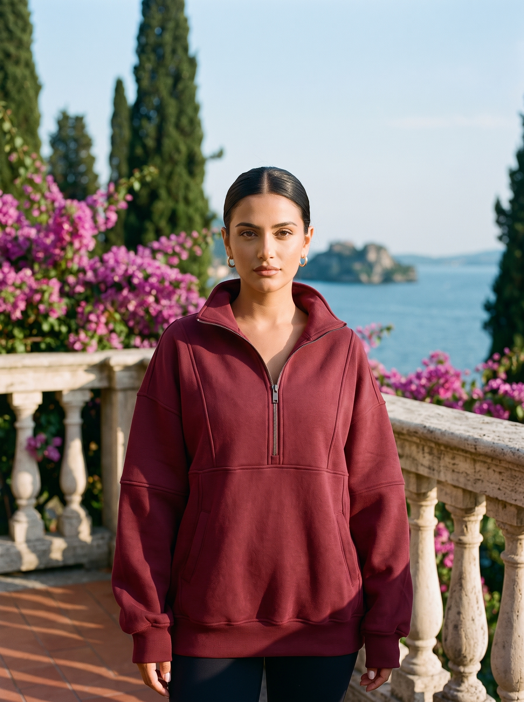 Woman wearing a burgundy oversized half-zip pocket sweatshirt on a Lake Como terrace — Aveloire