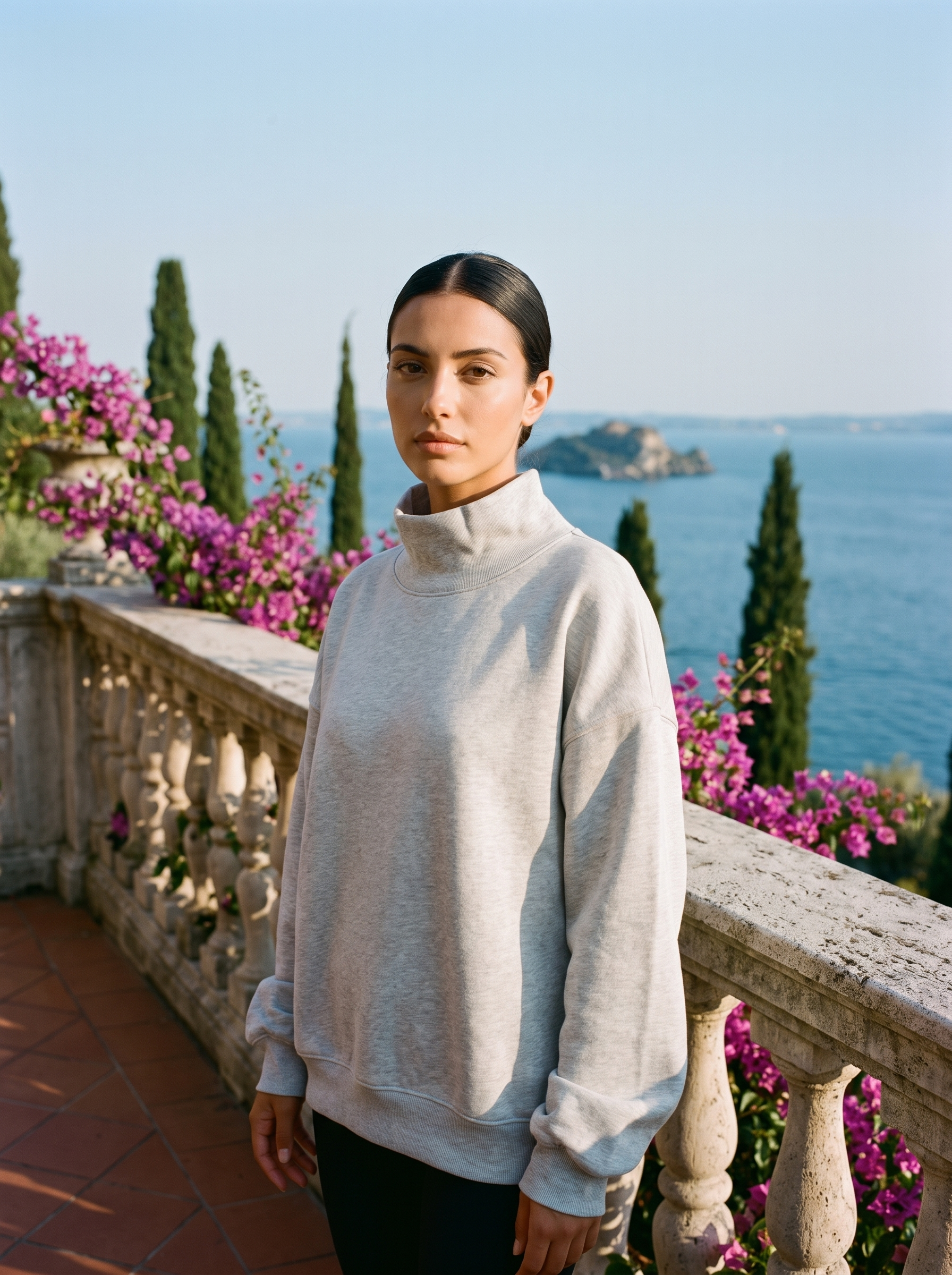 Woman wearing a light gray oversized turtleneck sweatshirt on a Lake Como terrace, old money style — Aveloire