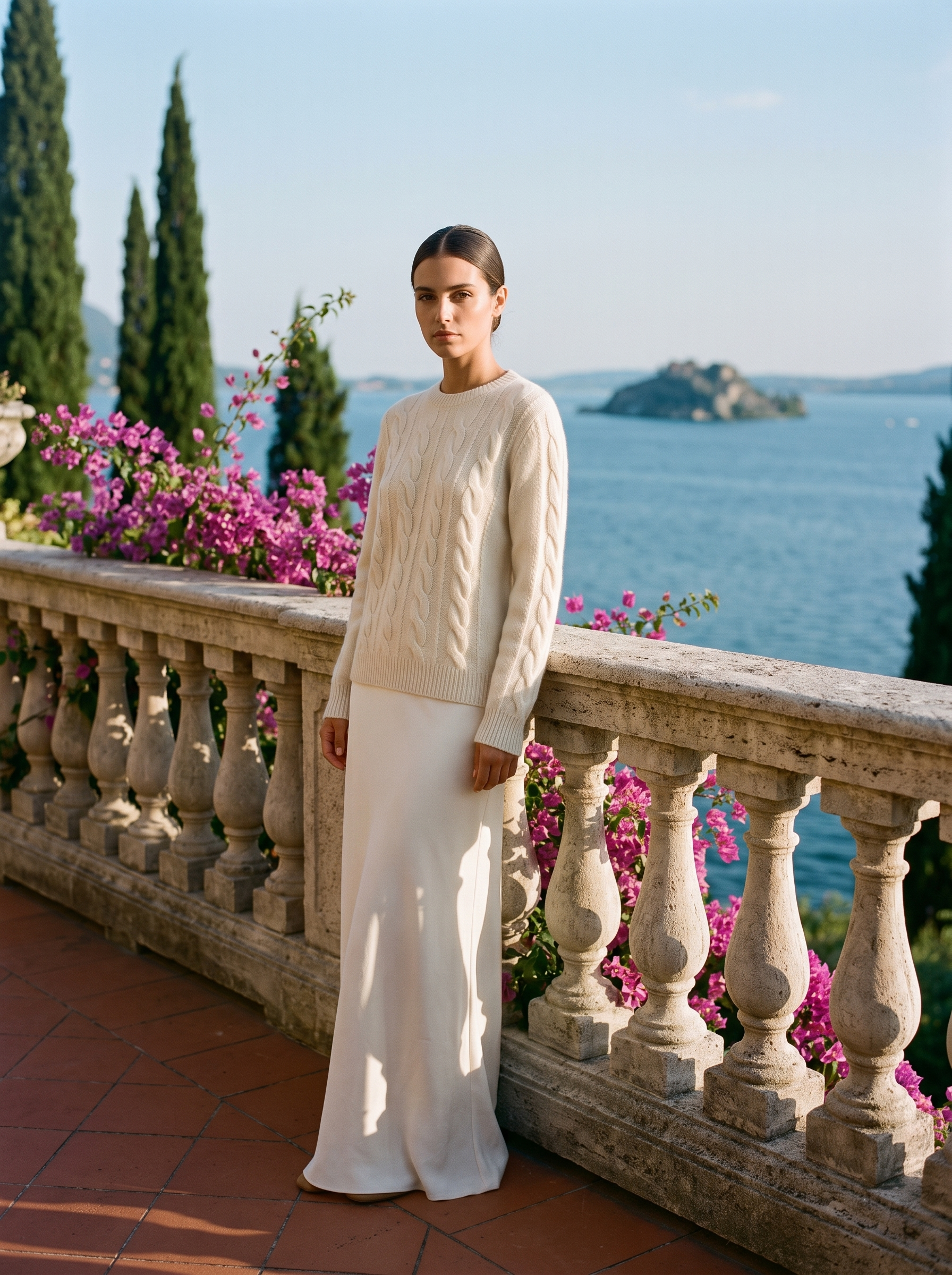 Full-length view of a cream cable-knit crew neck sweater on a Lake Como terrace — Aveloire