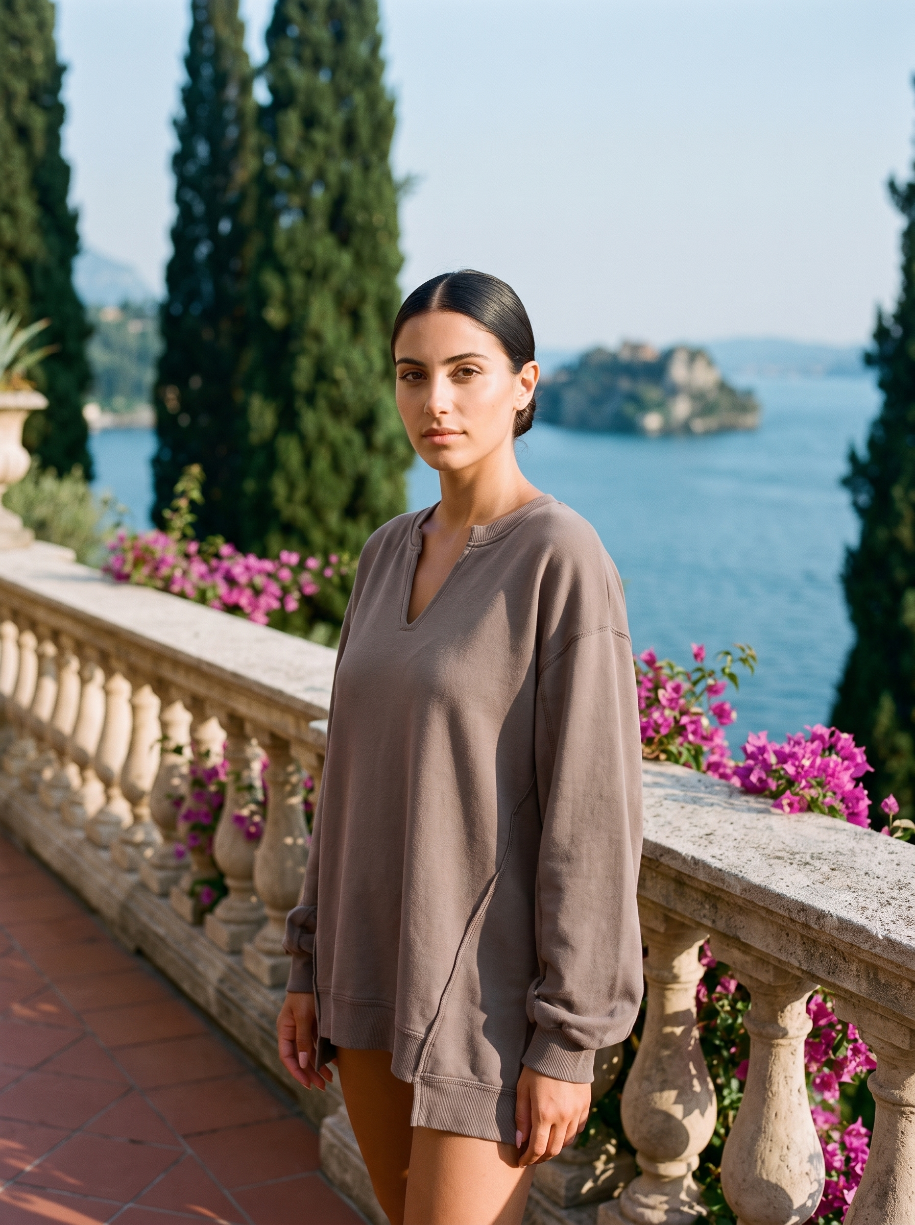 Woman wearing a mushroom taupe V-neck sweatshirt tunic on a Lake Como terrace, old money style — Aveloire