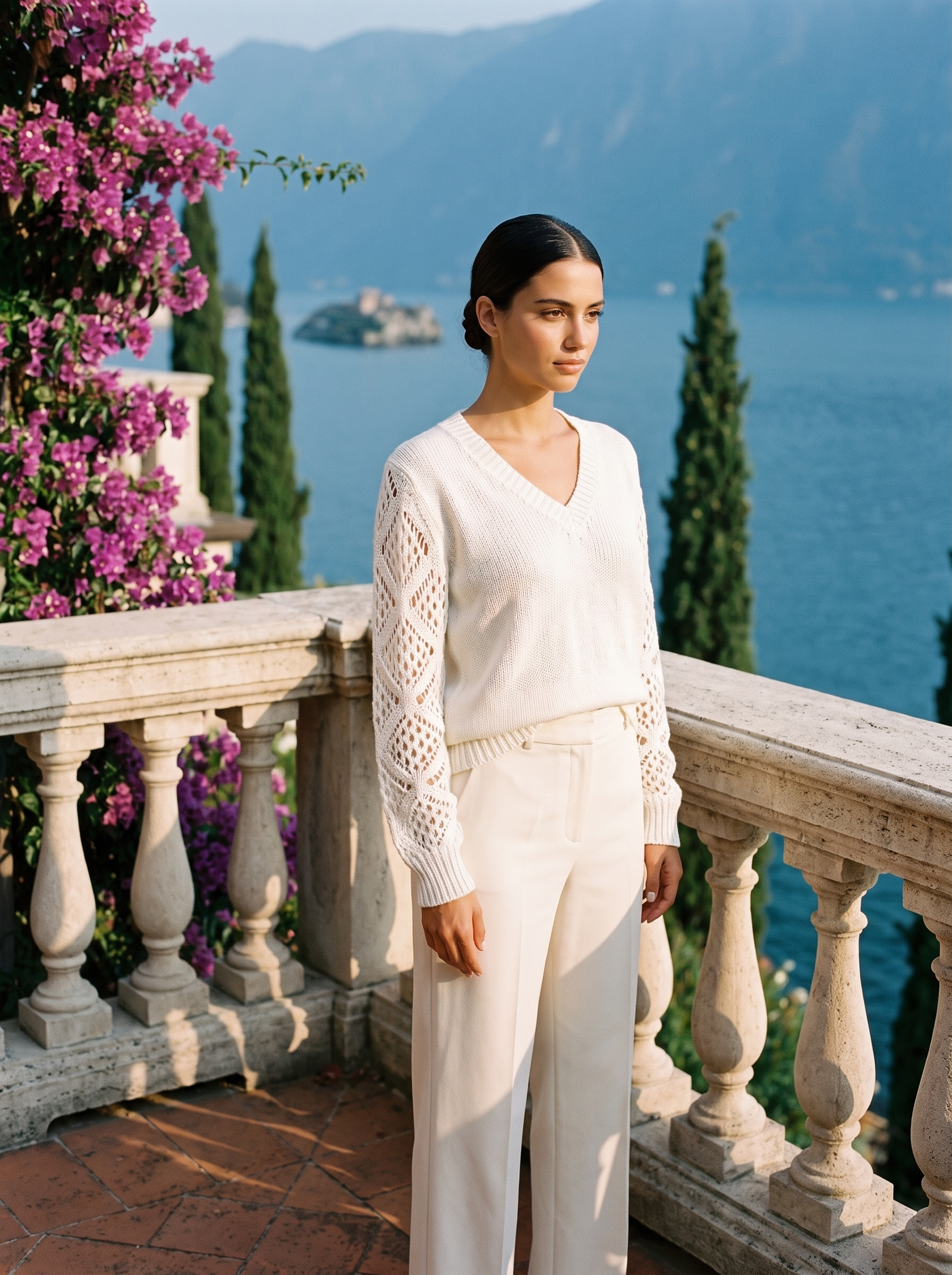 Woman wearing an ivory V-neck knit jumper full length on a Lake Como terrace, old money style — Aveloire
