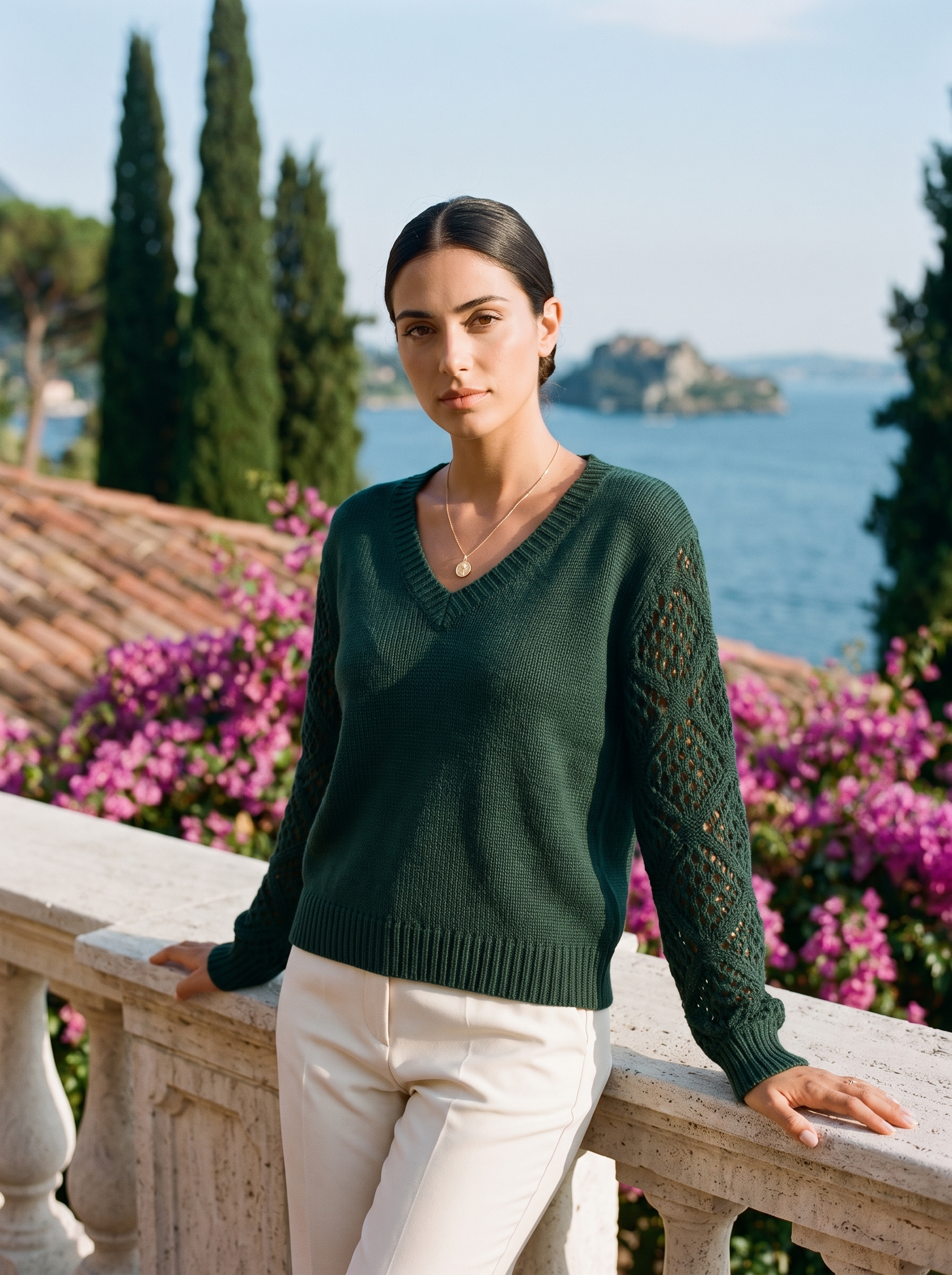 Woman wearing a dark green V-neck knit jumper on a Lake Como terrace, old money style — Aveloire