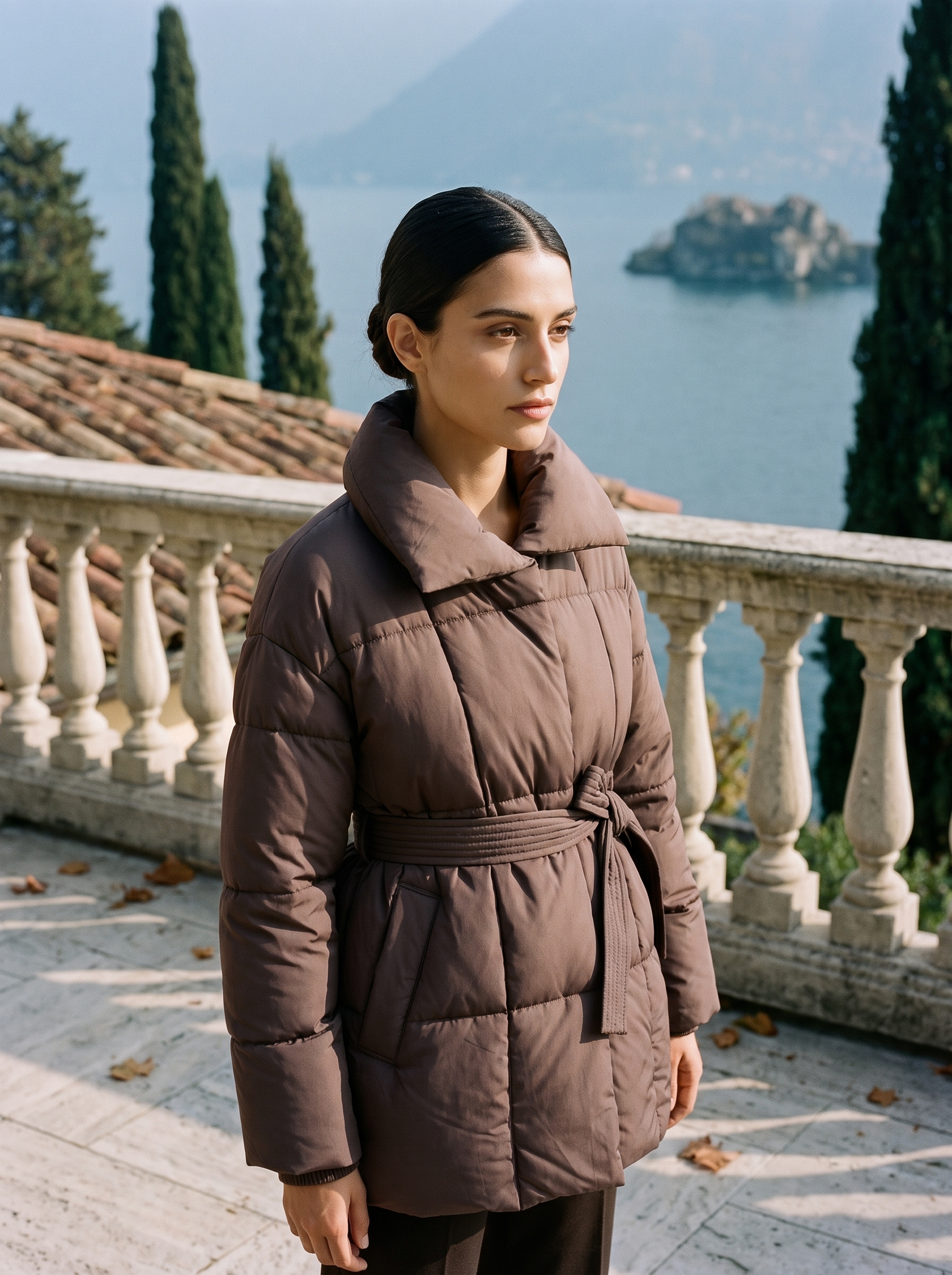 Chocolate brown belted quilted coat for women, worn on a Lake Como terrace — Aveloire