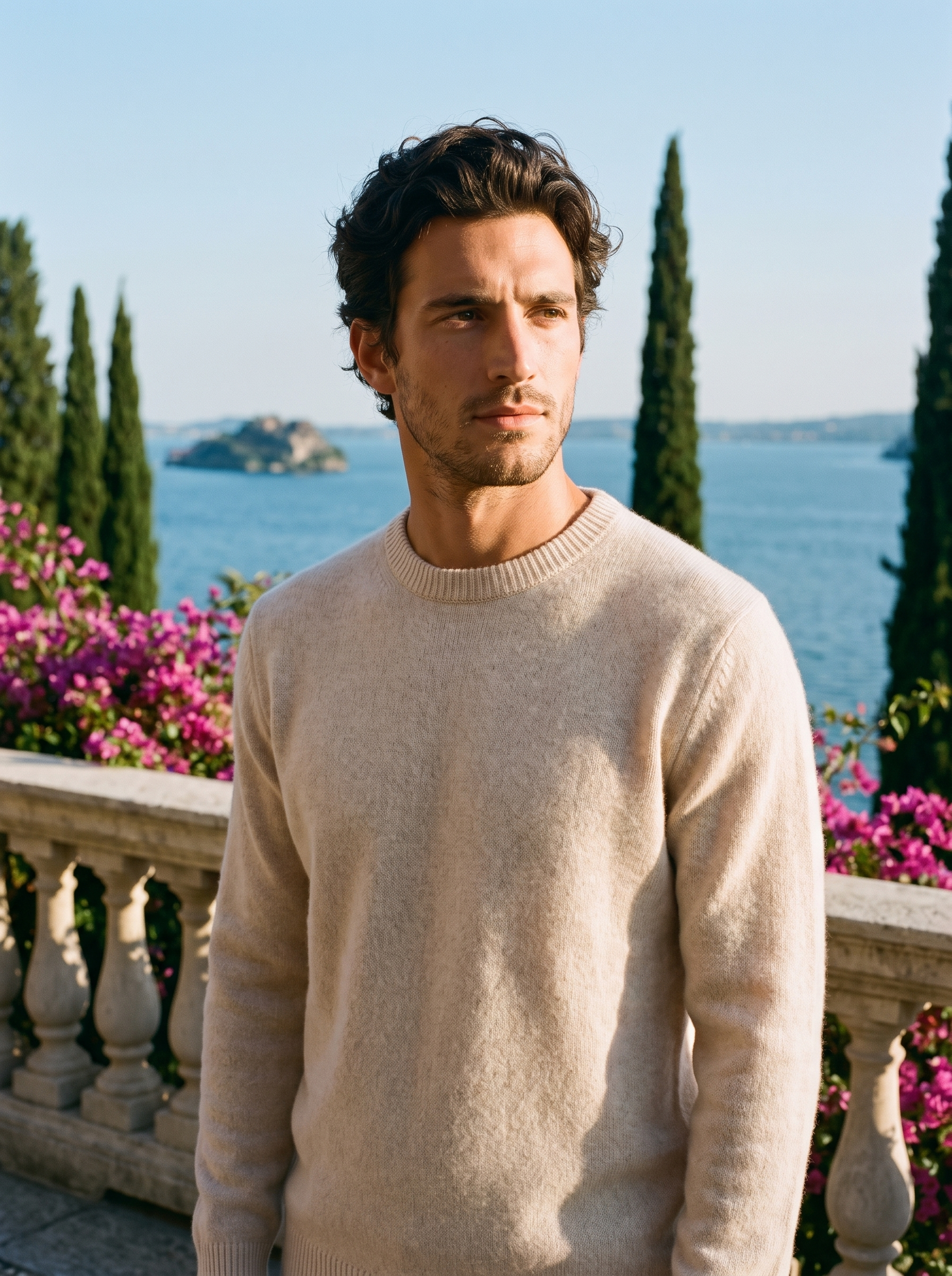 Man wearing a beige classic crewneck sweater on a terrace overlooking Lake Como, old money style — Aveloire