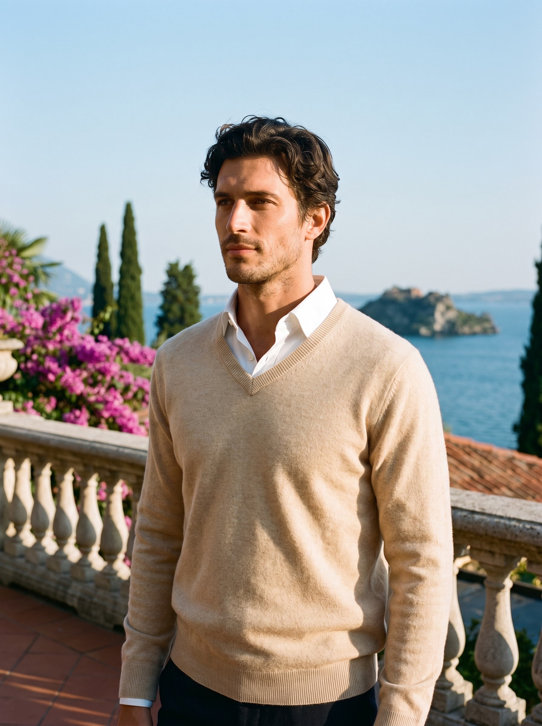 Man wearing a beige wool V-neck sweater over a white shirt on a terrace overlooking Lake Como — Aveloire
