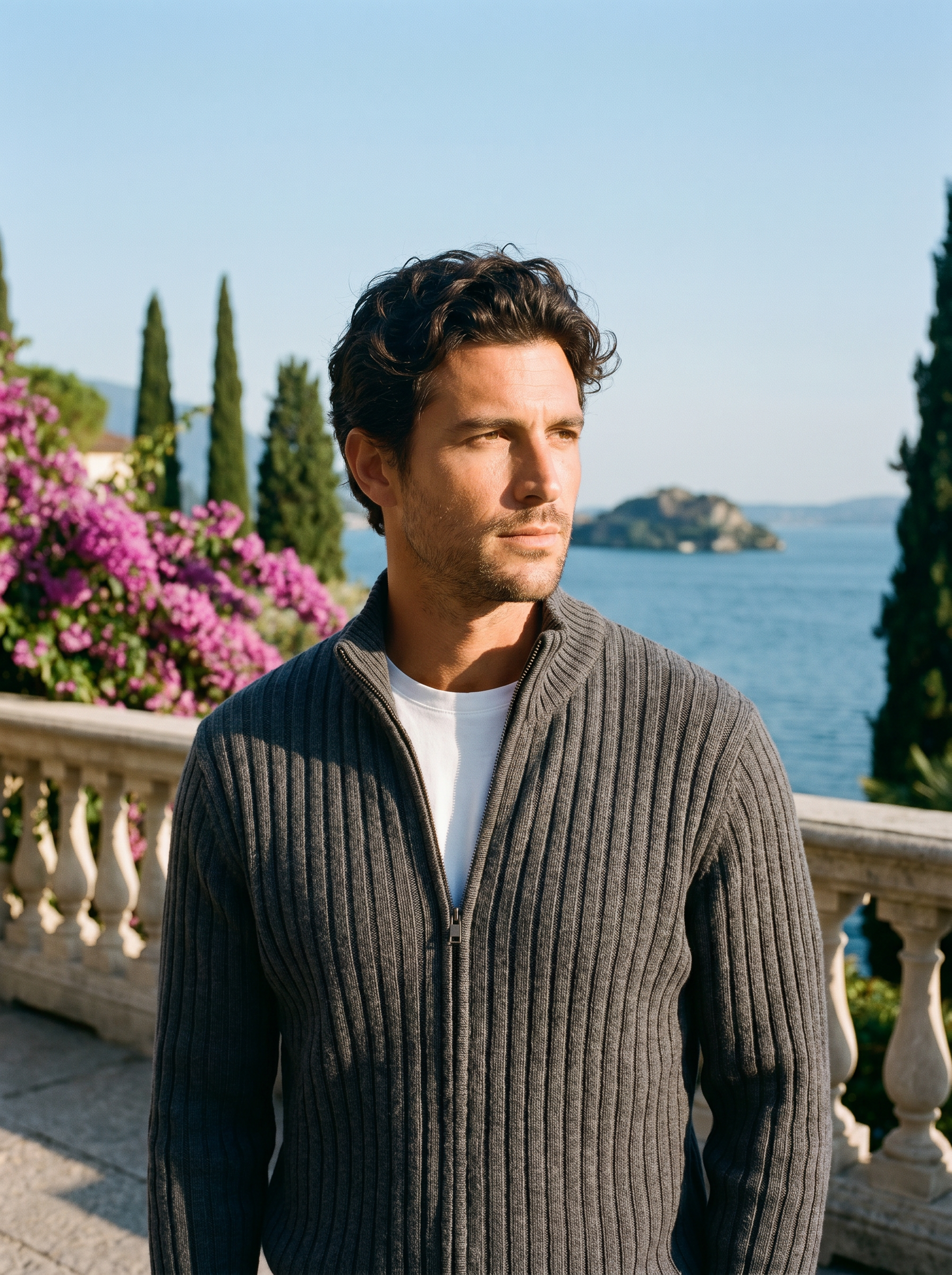 Man wearing a dark gray ribbed cotton full-zip cardigan on a terrace overlooking Lake Como, old money style — Aveloire