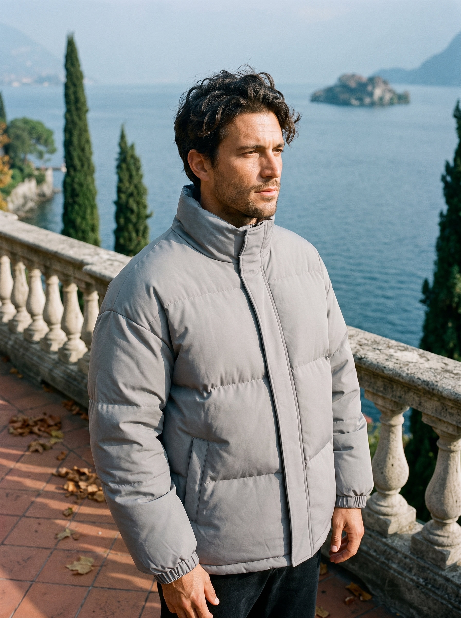 Light gray puffer jacket for men, worn on a Lake Como terrace — Aveloire