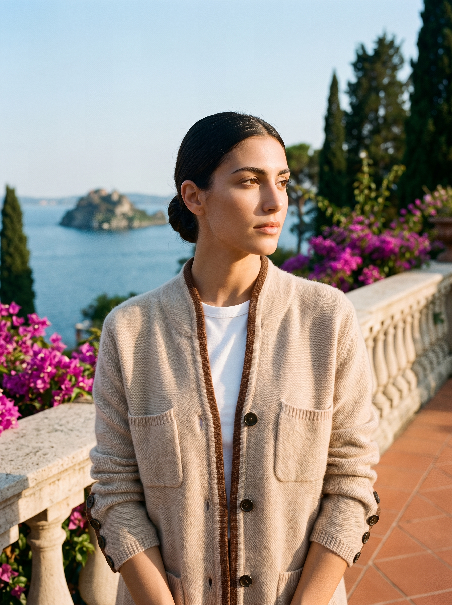 Woman wearing a beige cashmere cardigan on a terrace overlooking Lake Como, old money style — Aveloire