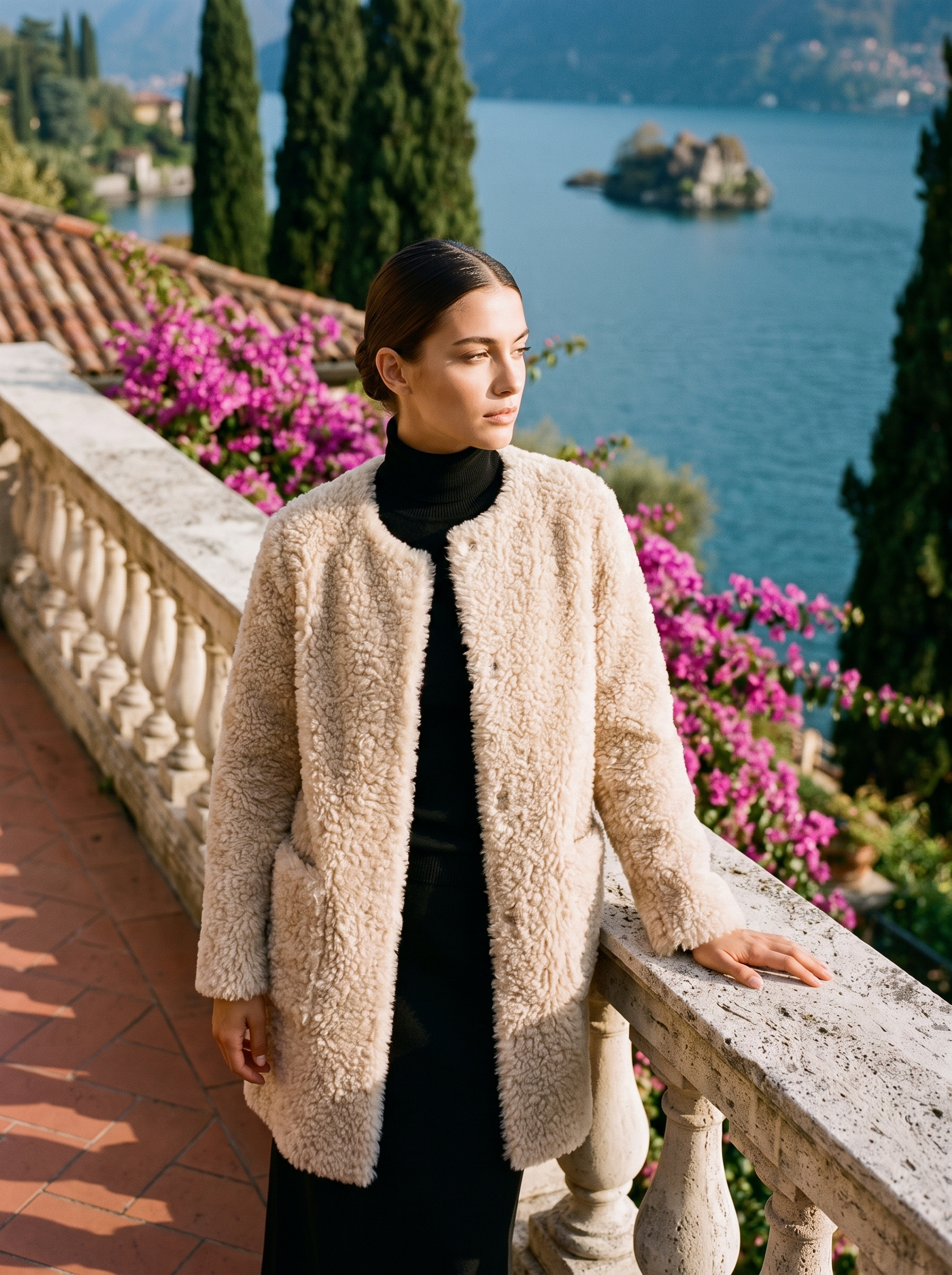 Woman wearing an oatmeal-cream shearling teddy coat on a Lake Como terrace — Aveloire