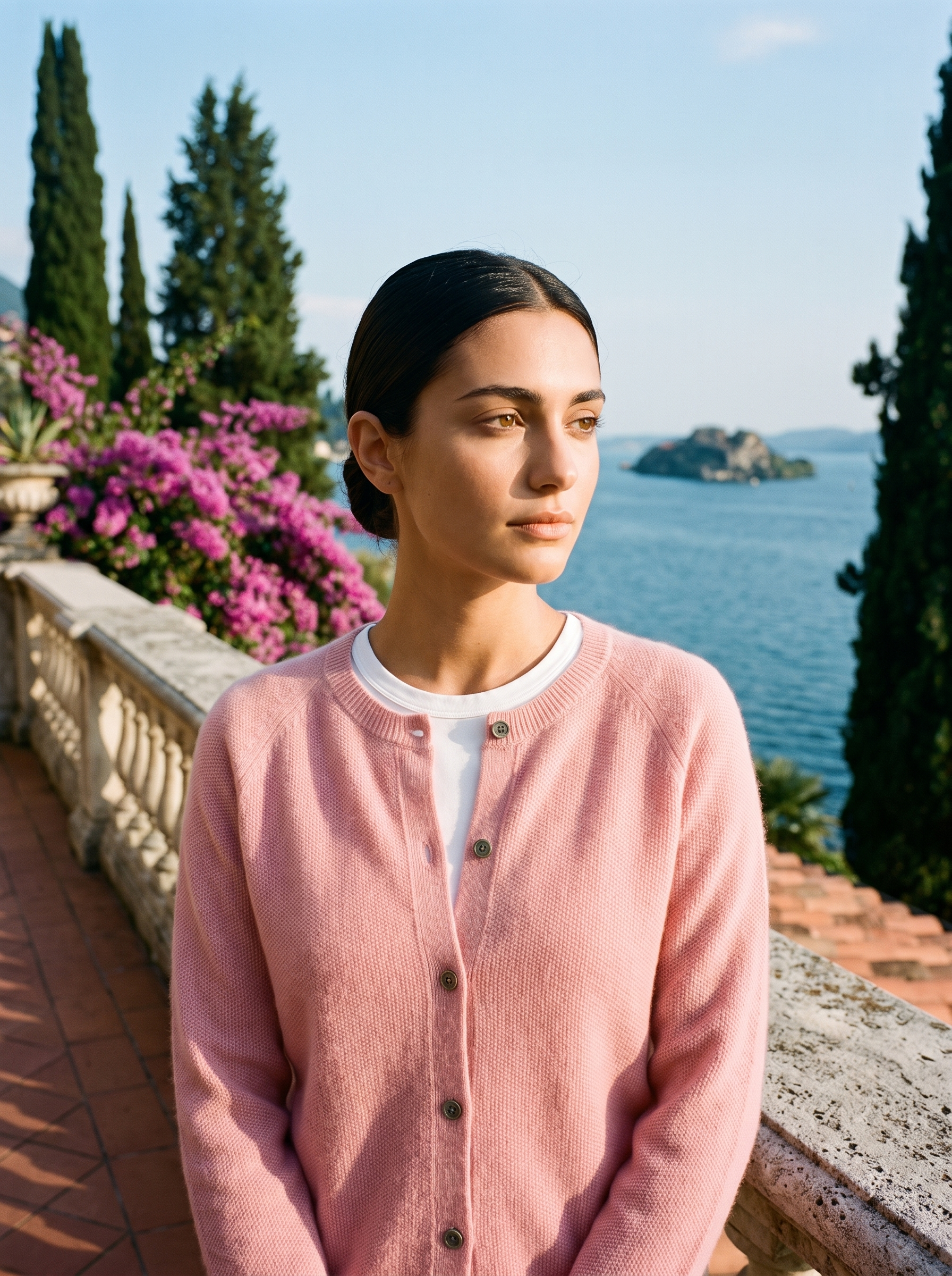 Woman wearing a pink wool-blend cardigan on a terrace overlooking Lake Como, old money style — Aveloire