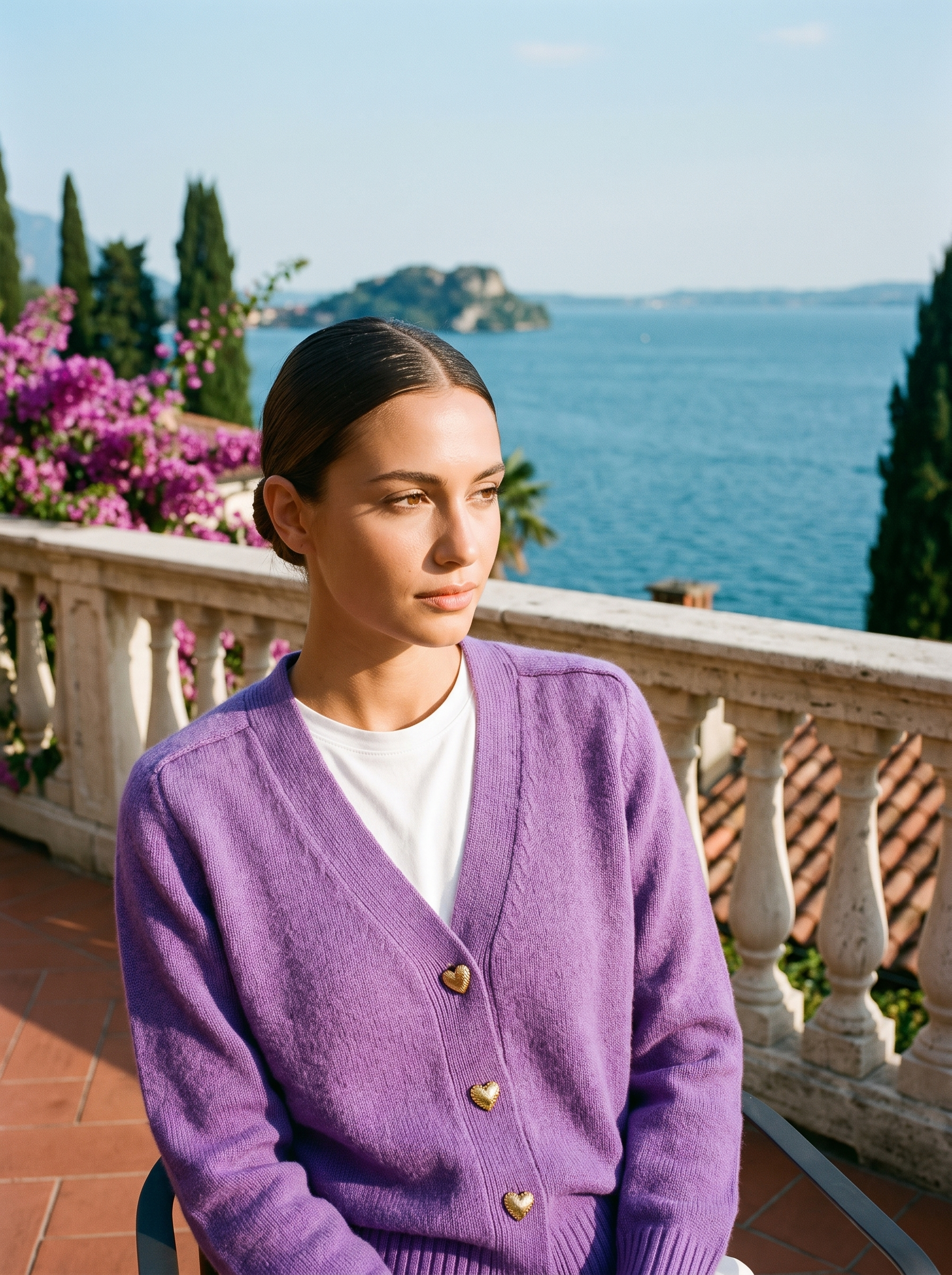 Woman wearing a purple V-neck button cardigan on a terrace overlooking Lake Como, old money style — Aveloire