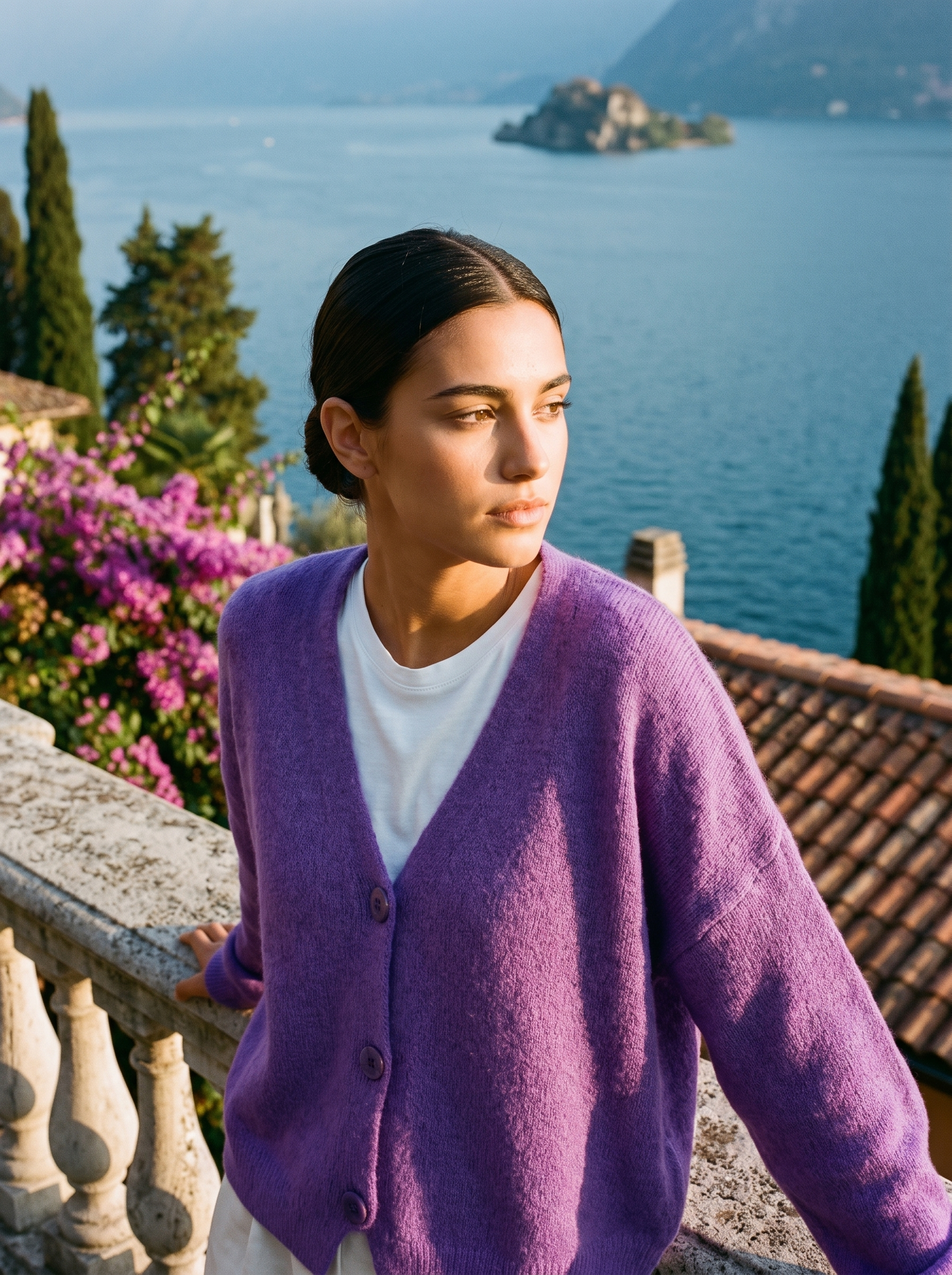 Woman wearing a purple V-neck cardigan on a terrace overlooking Lake Como, old money style — Aveloire
