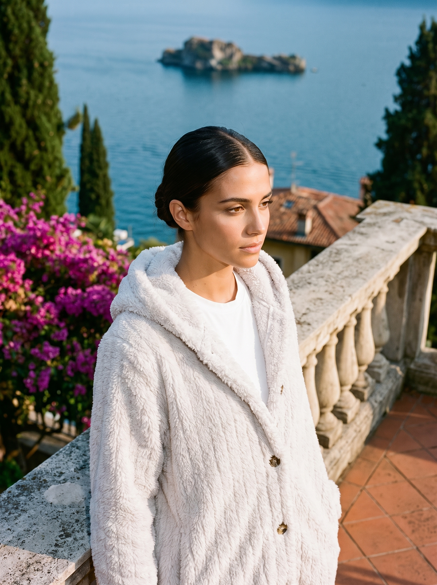 Woman wearing a white hooded cardigan on a terrace overlooking Lake Como, old money style — Aveloire