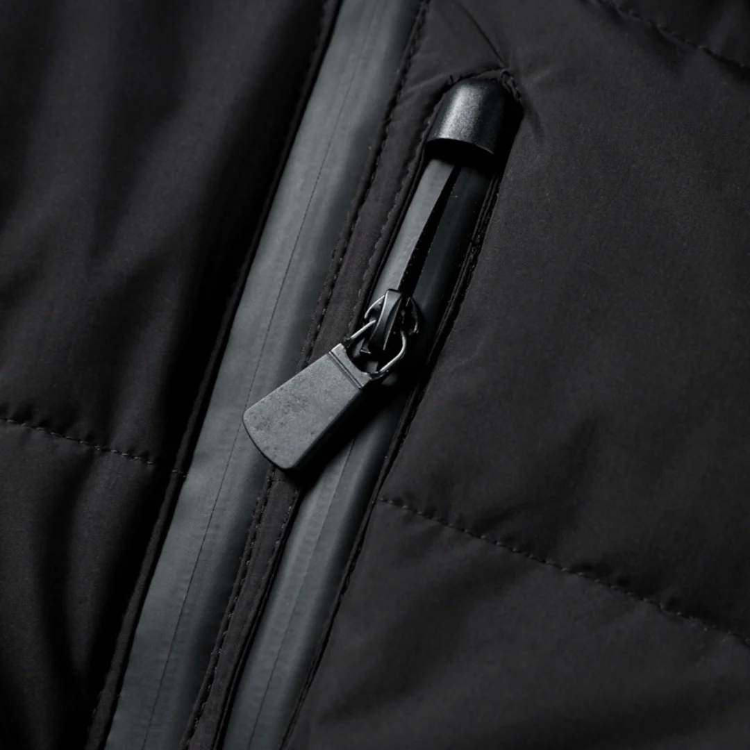 Close-up of the pocket zip pull on the black puffer coat — Aveloire