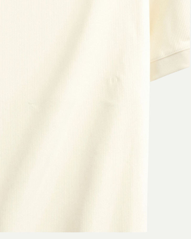 Close-up of cream knit polo shirt fabric texture