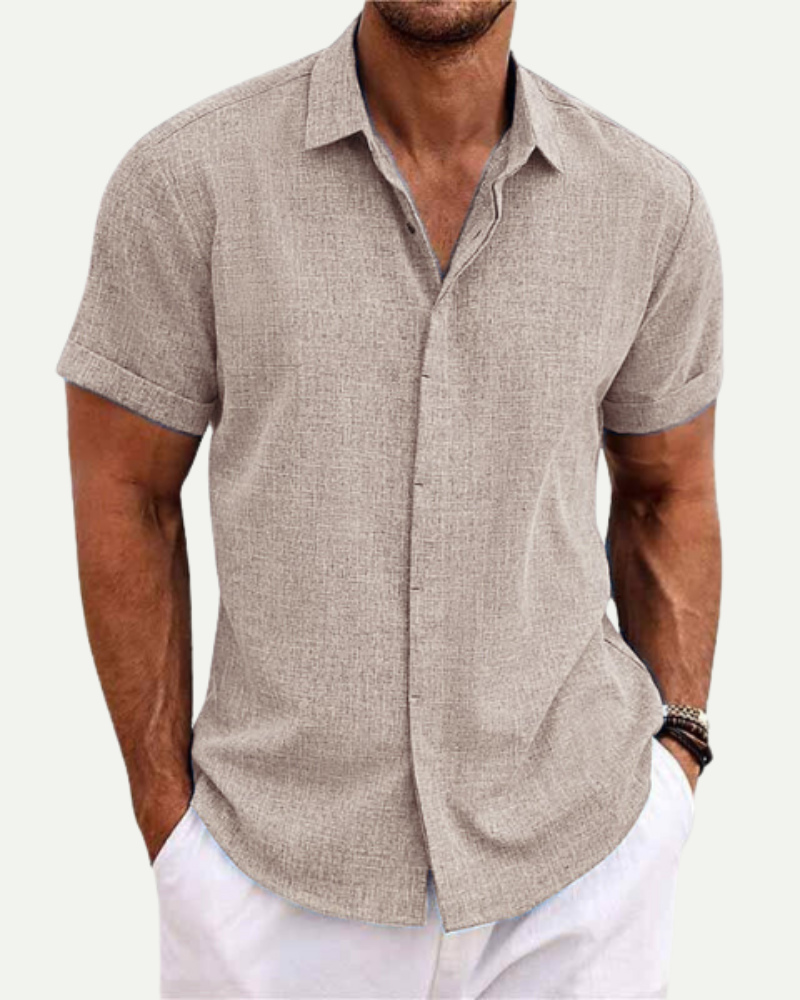Man wearing a beige short-sleeve shirt with a white background