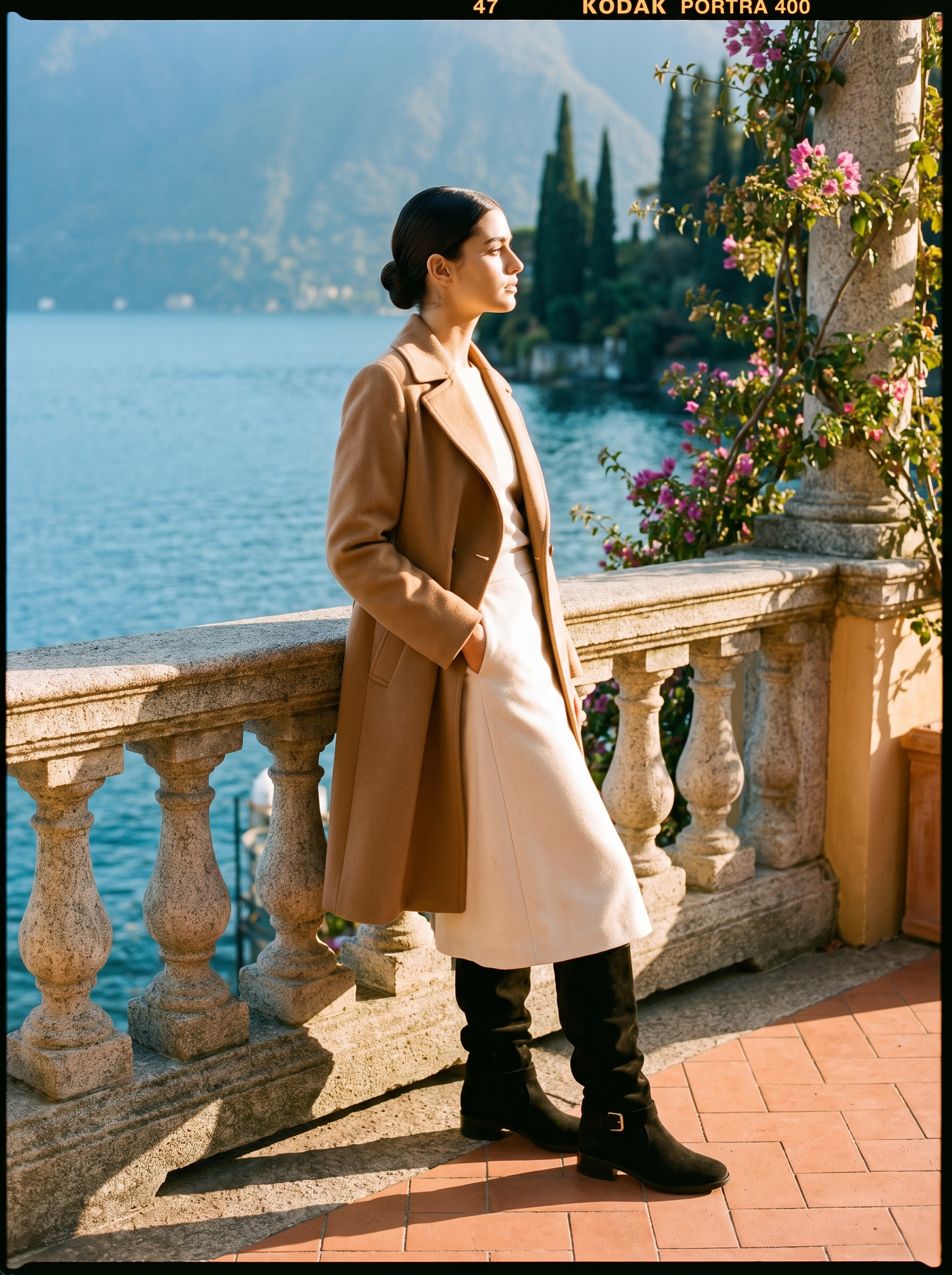 Black slouch knee high boots styled with cream midi skirt and camel coat