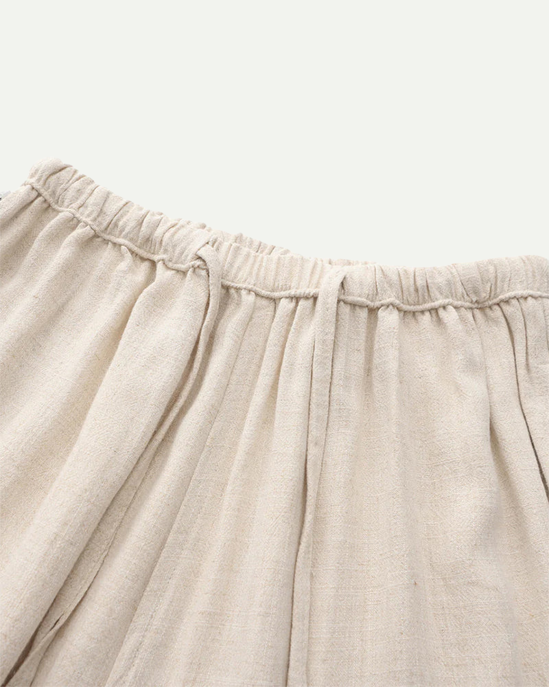 Close-up of beige  linen pants with an elastic waistband on a light background