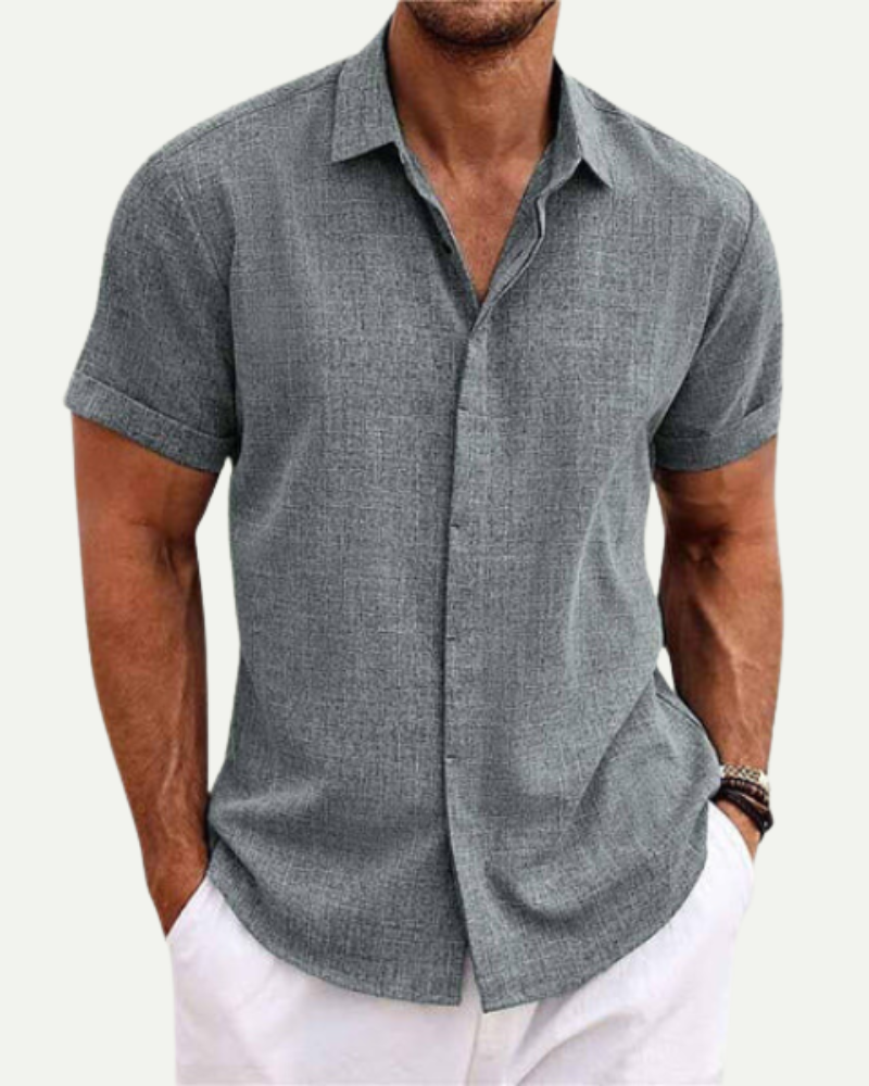 Man wearing a gray short-sleeve button-up shirt on a white background