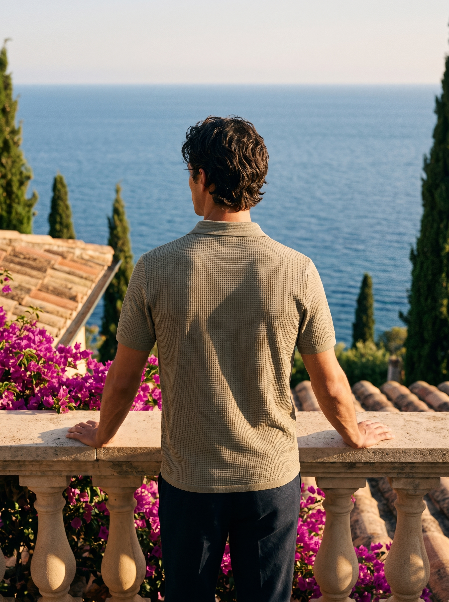 Back view of a man in a khaki basketweave knit polo overlooking Lake Como — Aveloire