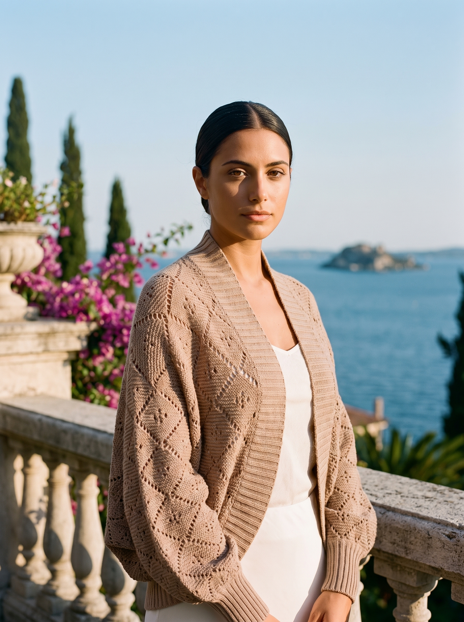 Woman wearing a warm beige cropped open-front knit shrug cardigan on a Lake Como terrace — Aveloire