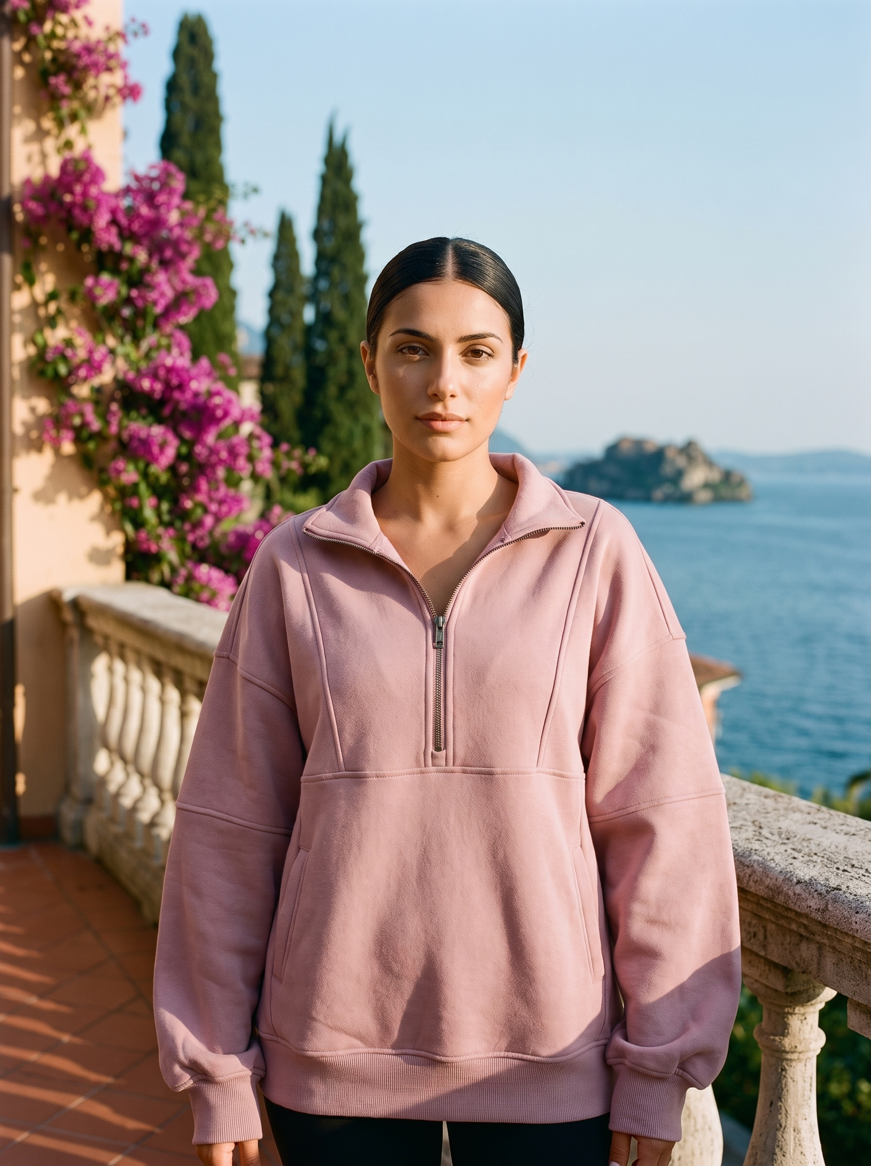 Woman wearing a rose pink oversized half-zip pocket sweatshirt on a Lake Como terrace — Aveloire