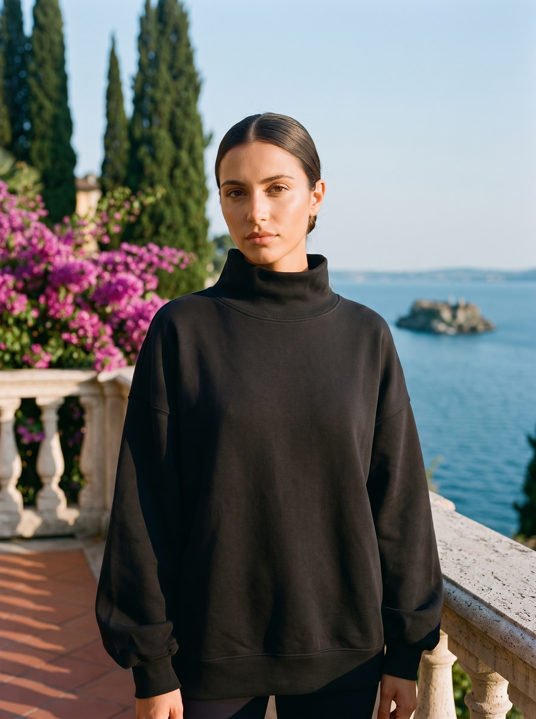 Woman wearing a black oversized turtleneck sweatshirt on a Lake Como terrace — Aveloire