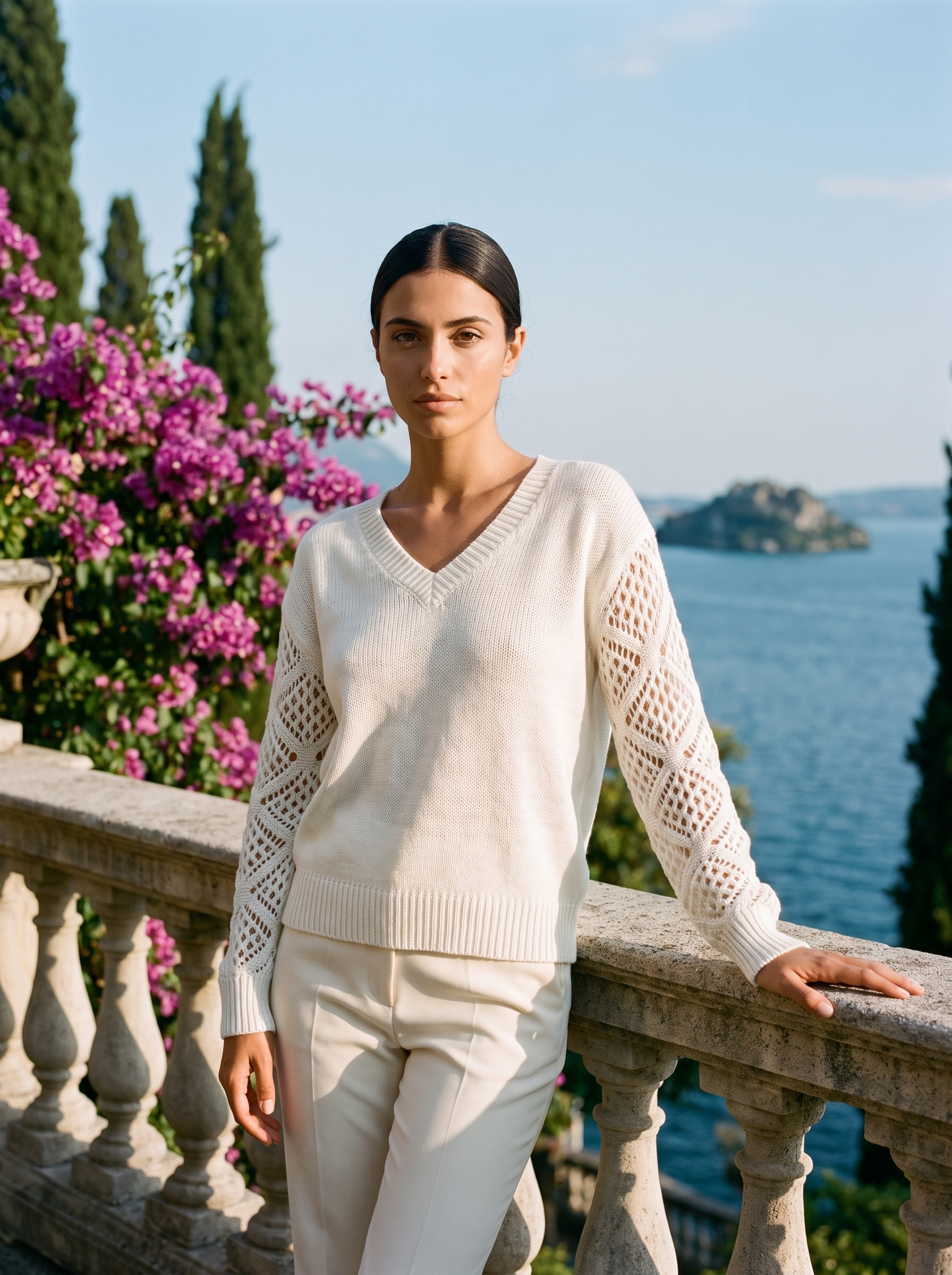 Woman wearing an ivory V-neck knit jumper on a Lake Como terrace, old money style — Aveloire