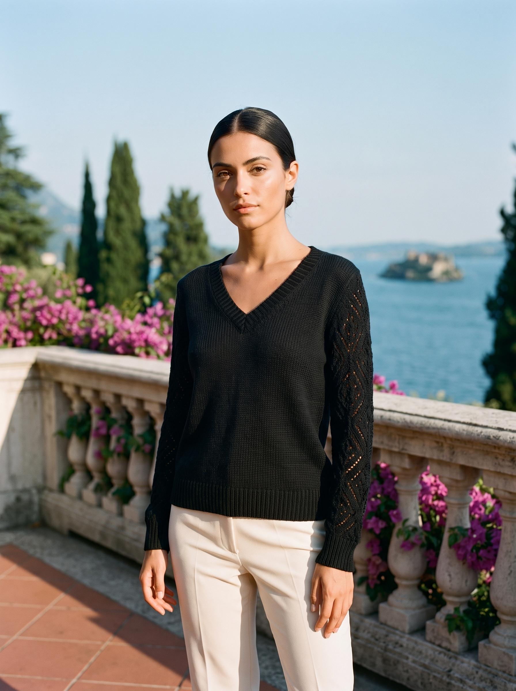 Woman wearing a black V-neck knit jumper on a Lake Como terrace, old money style — Aveloire