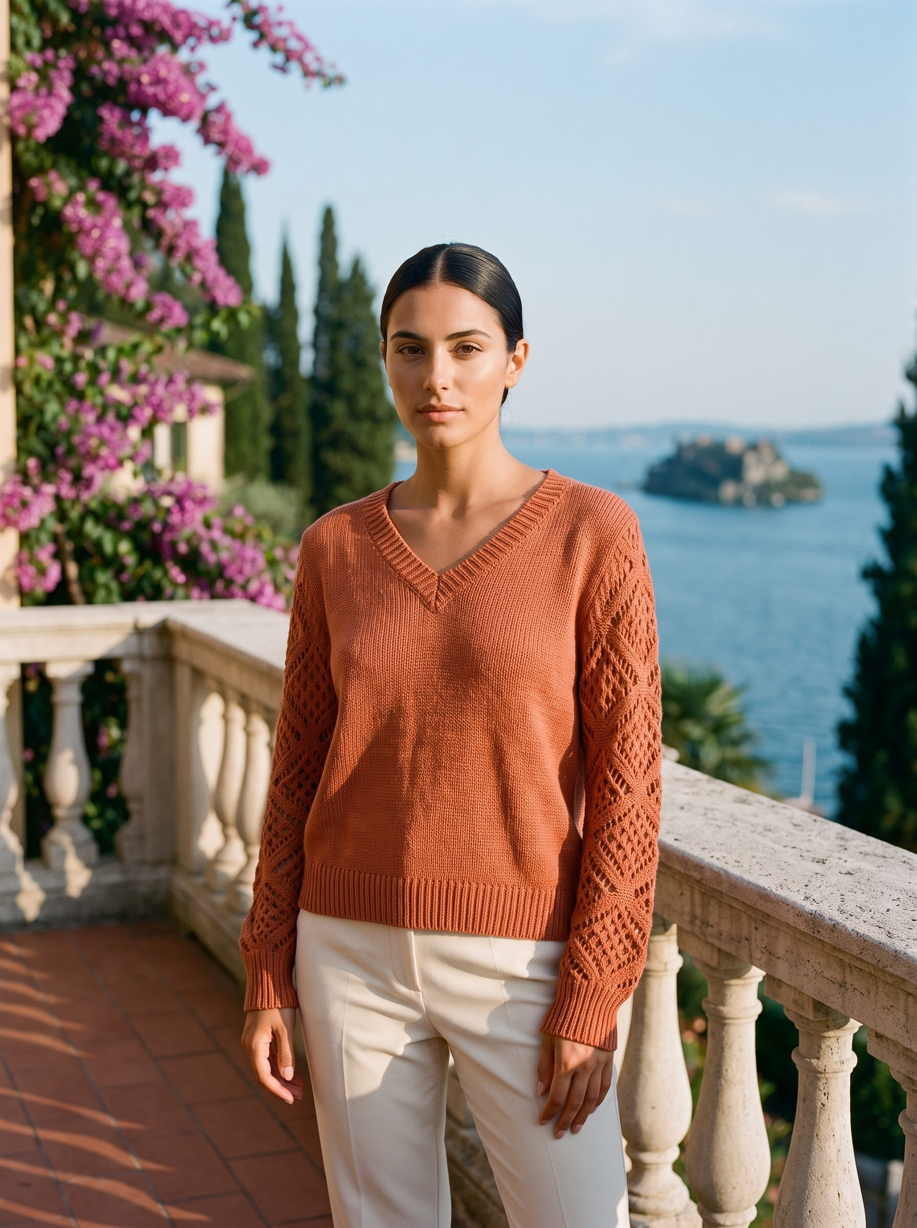 Woman wearing a rust orange V-neck knit jumper on a Lake Como terrace, old money style — Aveloire