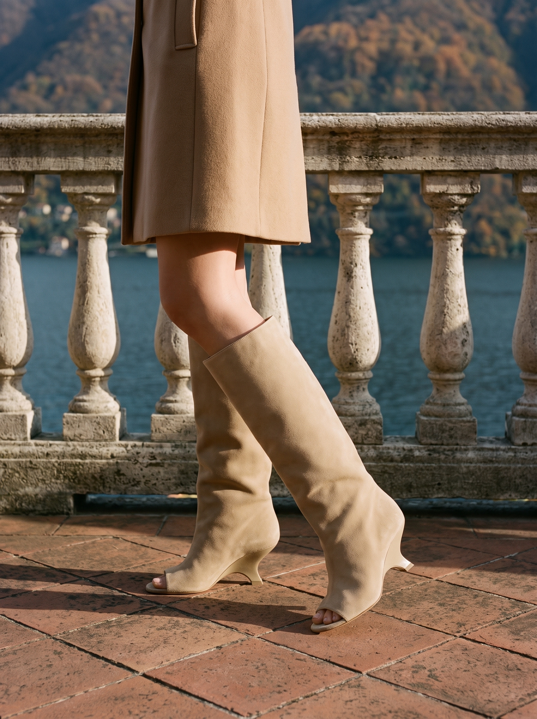 Sand beige peep toe knee high boots for women, worn on a Lake Como terrace — Aveloire