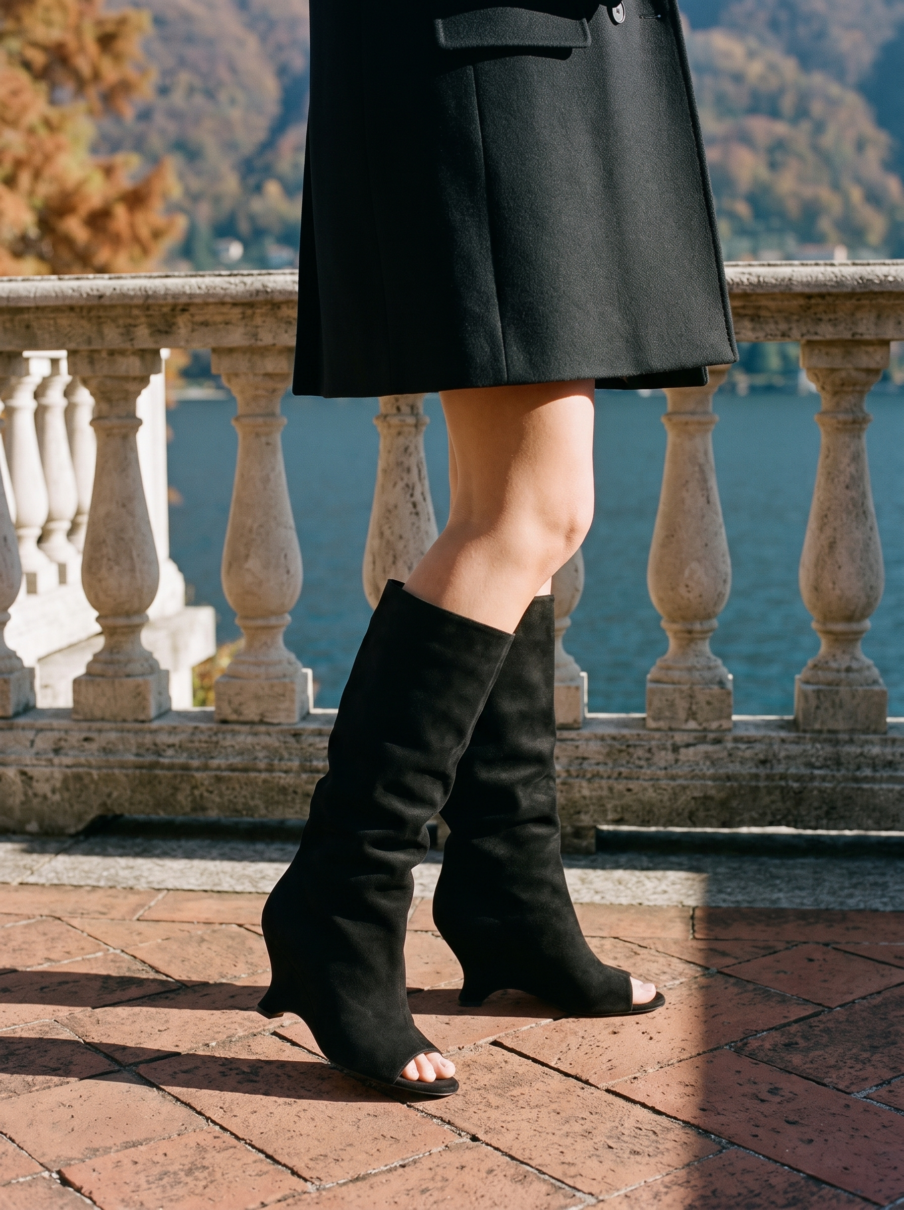 Black peep toe knee high boots for women, worn on a Lake Como terrace — Aveloire