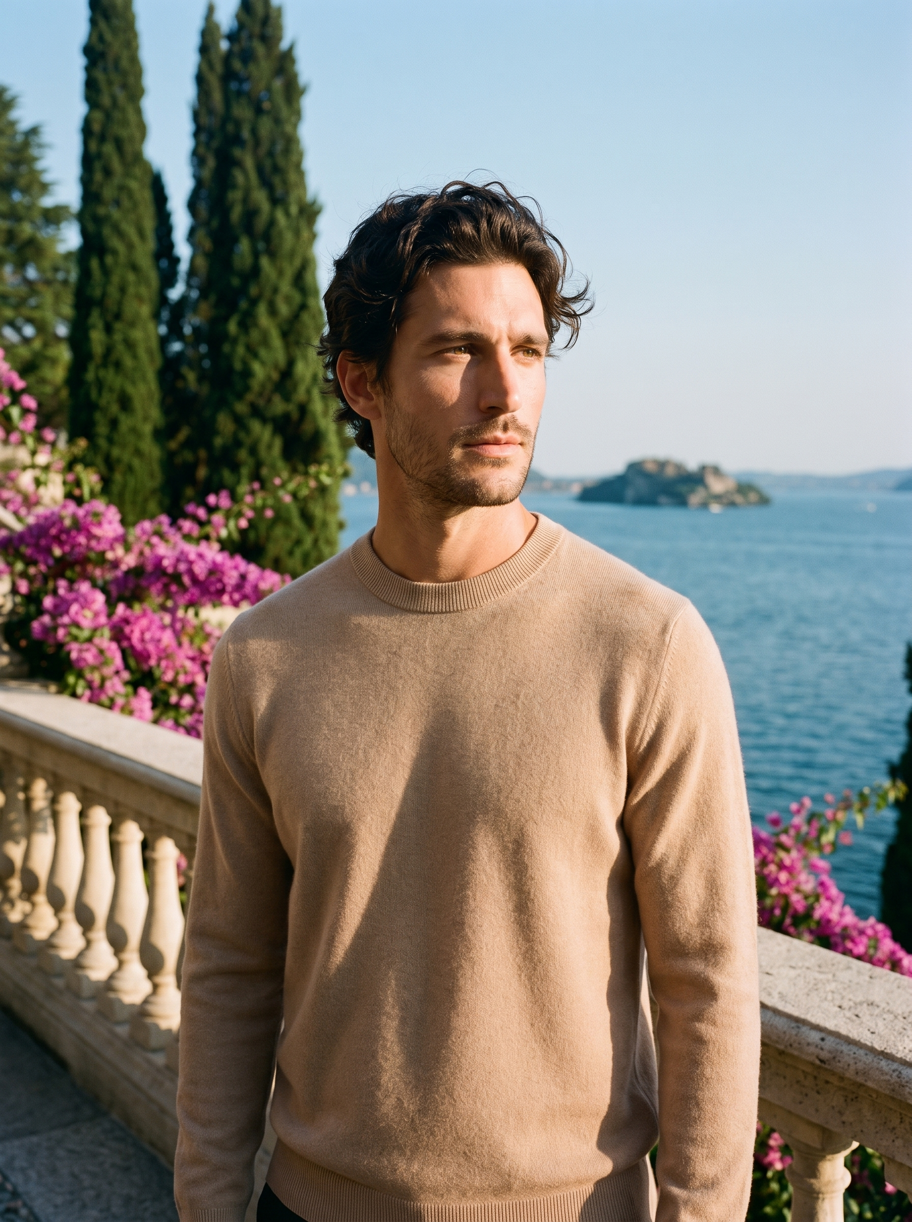Man wearing a beige 100% wool crewneck sweater on a terrace overlooking Lake Como, old money style — Aveloire