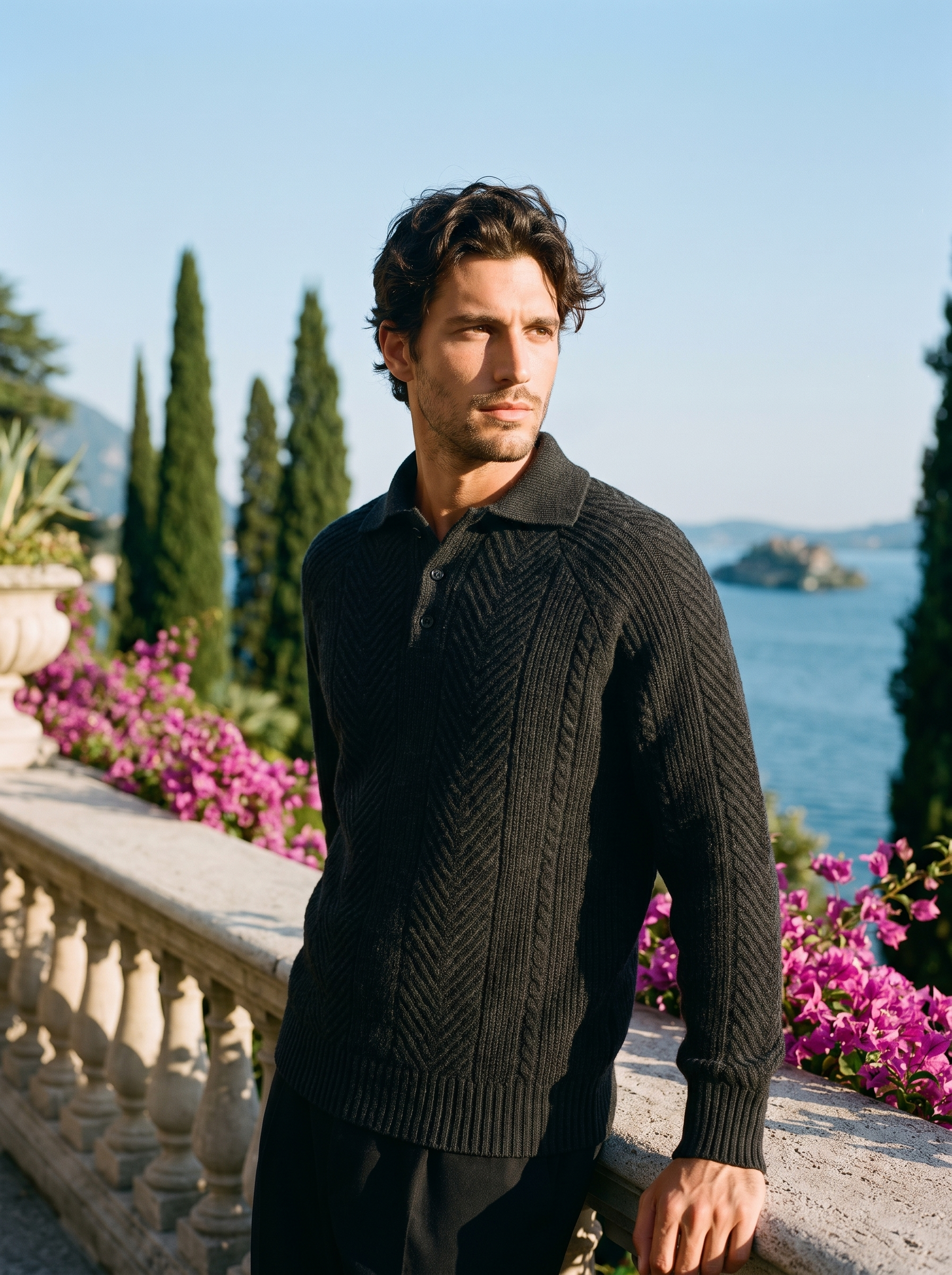 Man wearing a black herringbone knit polo sweater on a terrace overlooking Lake Como, old money style — Aveloire