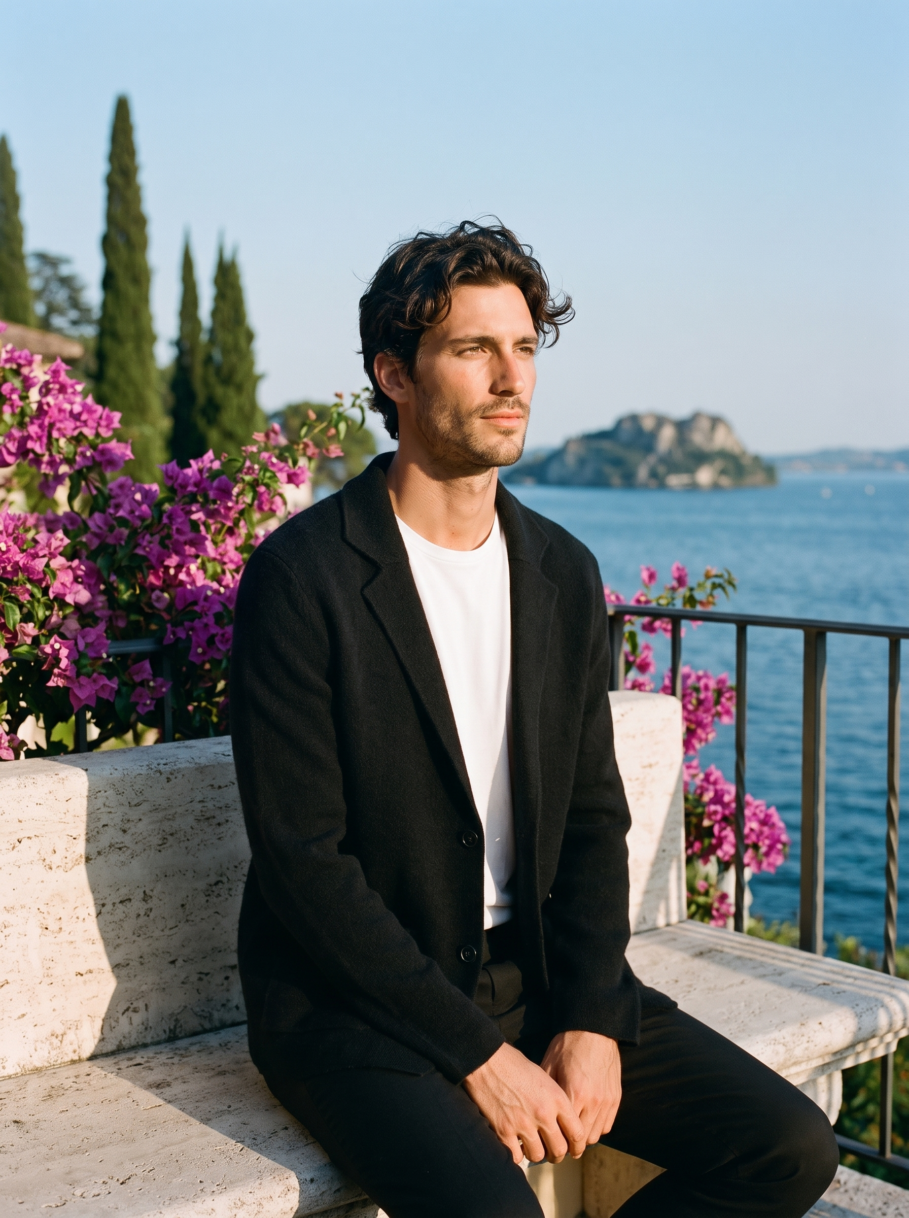 Man wearing a black wool blazer cardigan on a terrace overlooking Lake Como, old money style — Aveloire