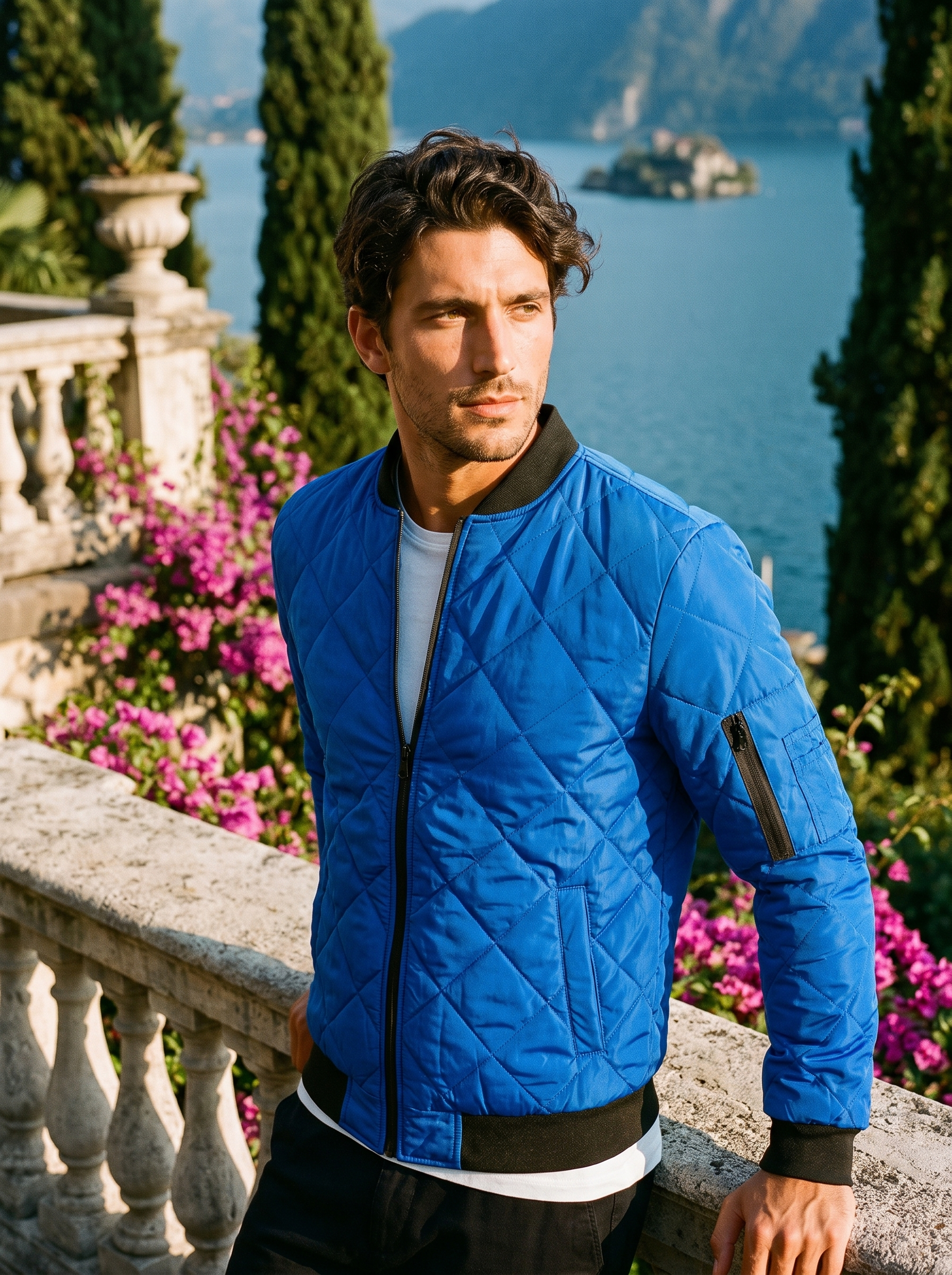 Man wearing a royal blue quilted bomber jacket on a terrace overlooking Lake Como, old money style — Aveloire