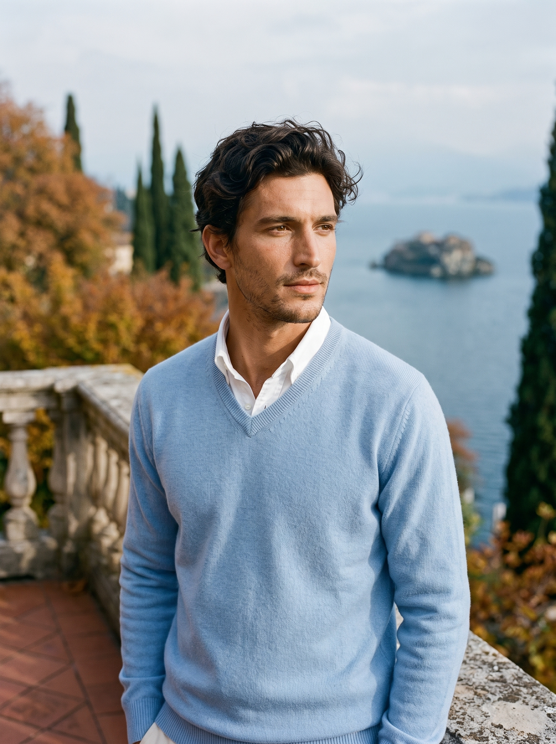 Light blue wool v neck sweater for men, worn on a Lake Como terrace — Aveloire