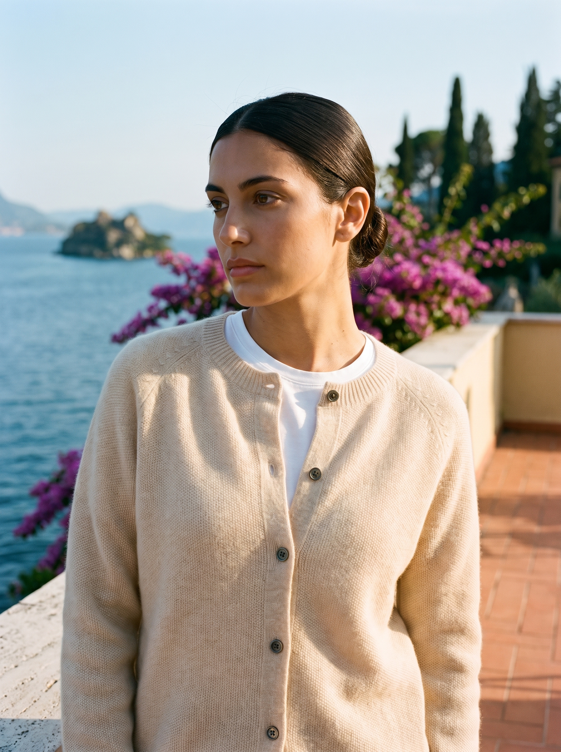 Woman wearing a beige wool-blend cardigan on a terrace overlooking Lake Como, old money style — Aveloire
