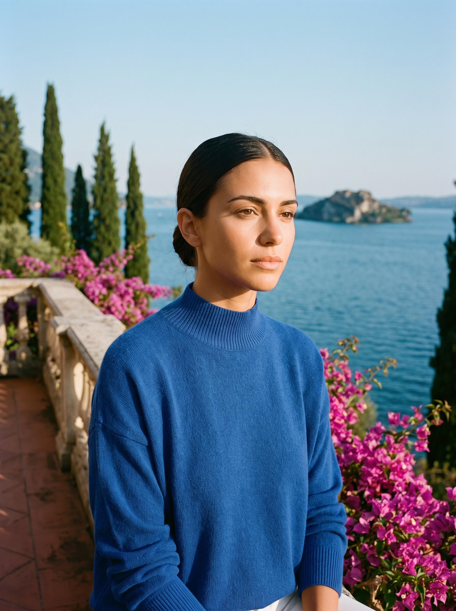 Woman wearing a blue mock-neck jumper on a terrace overlooking Lake Como — Aveloire